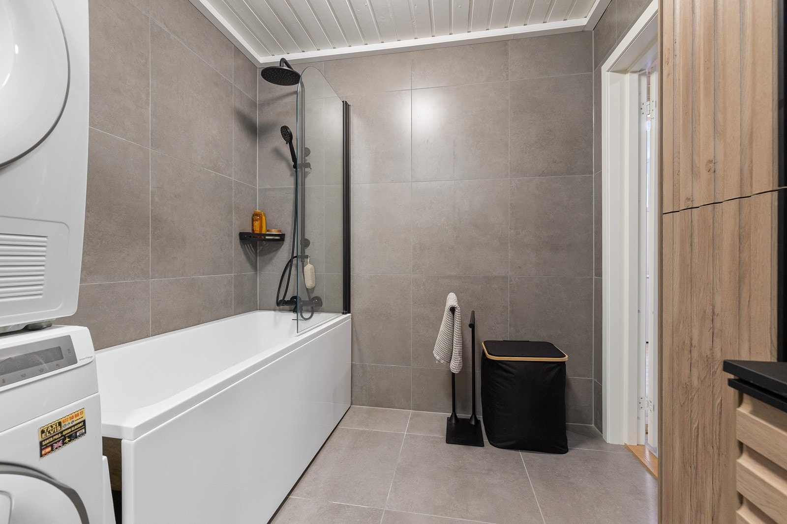Badet er innredet med servant i baderomsinnredning, veggskap, badekar med dusjarmatur og vegghengt toalett. Galleribilde