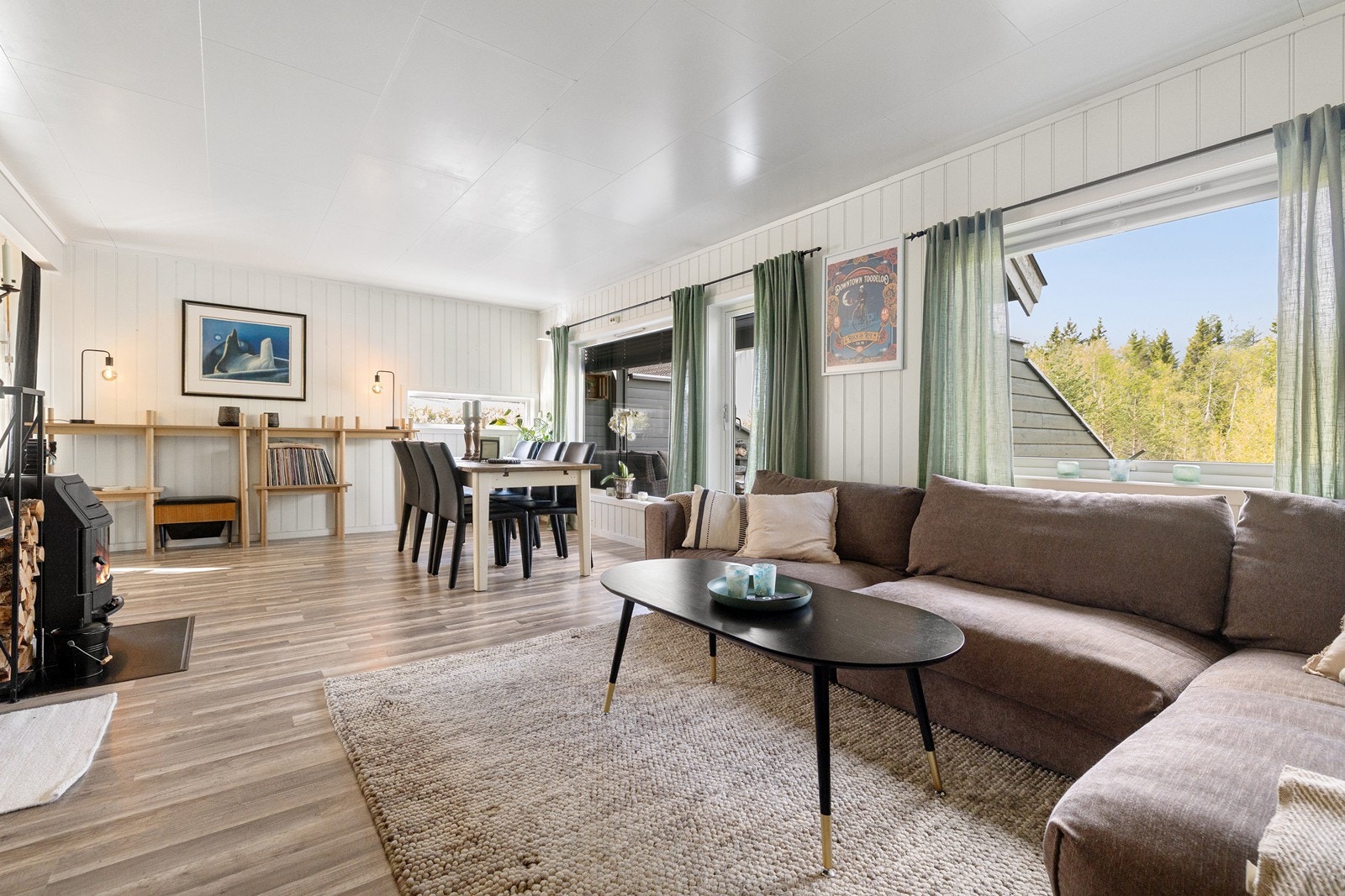 Stuen har lyst laminatgulv og trepanel på veggene. Galleribilde