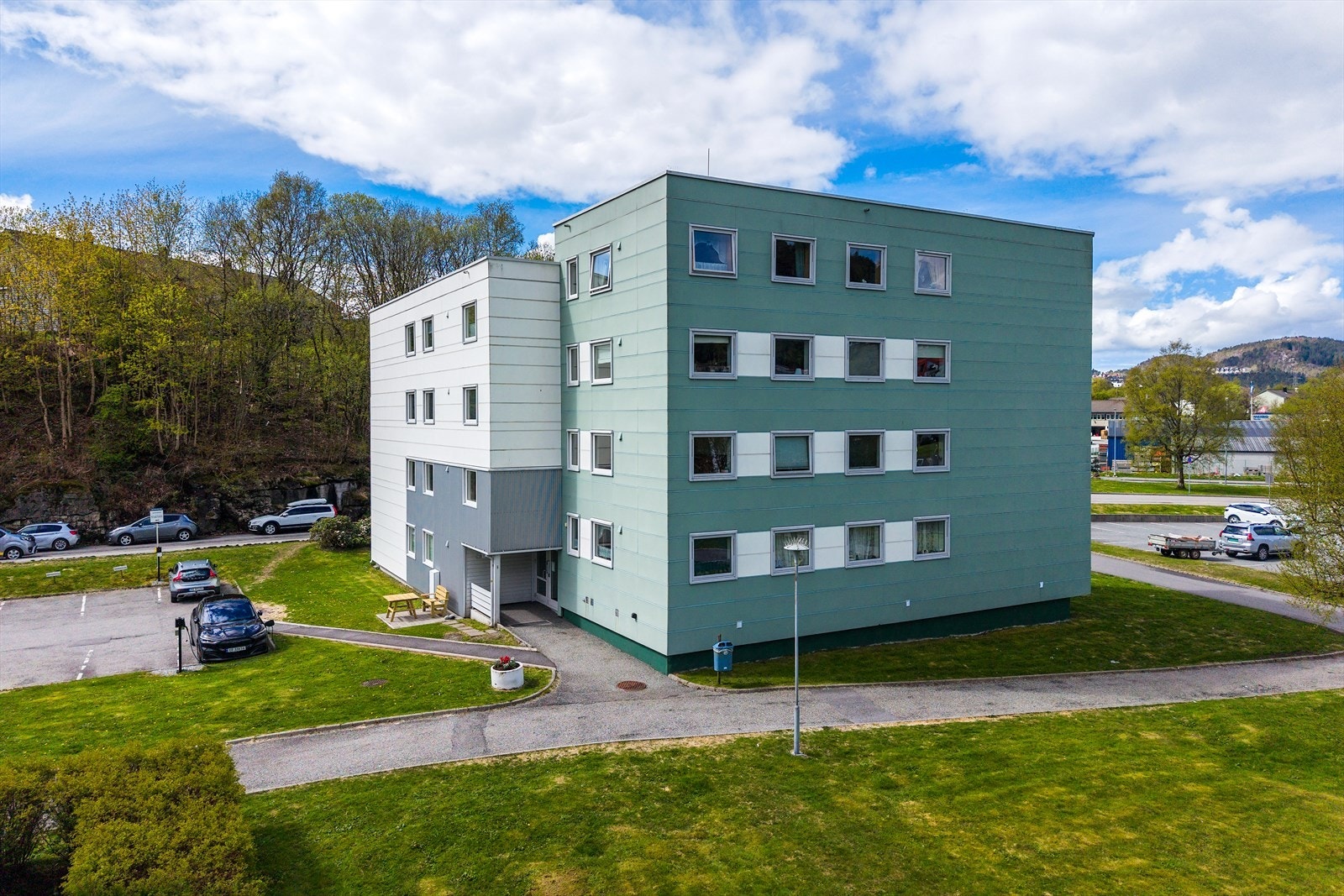 Tomten er felles for borettslaget og er fint opparbeidet med interne veier, parkeringsplasser, lekeplasser og diverse plener og beplantninger Galleribilde