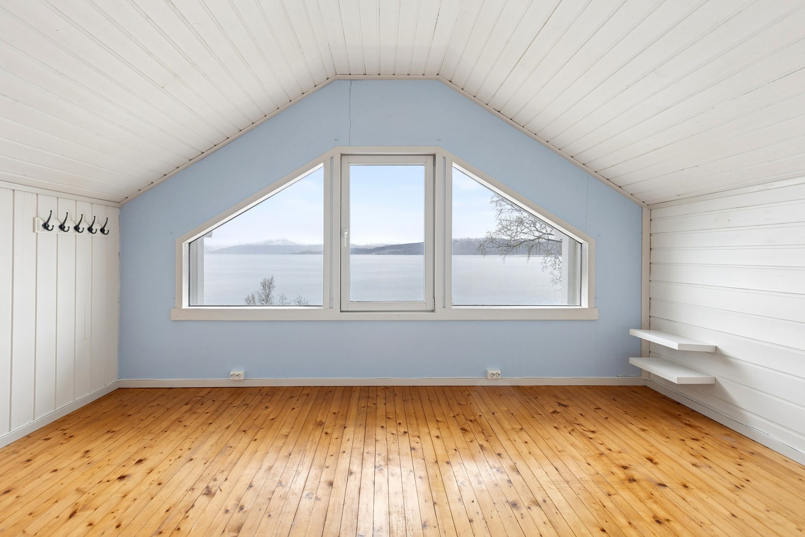 Loftsetasjen er innredet med to rom. Herfra er det en flott utsikt gjennom de karakteristiske vinduene. (Etasjen er ikke godkjent ifølge Evenes Kommune). Foto: EFKT Galleribilde