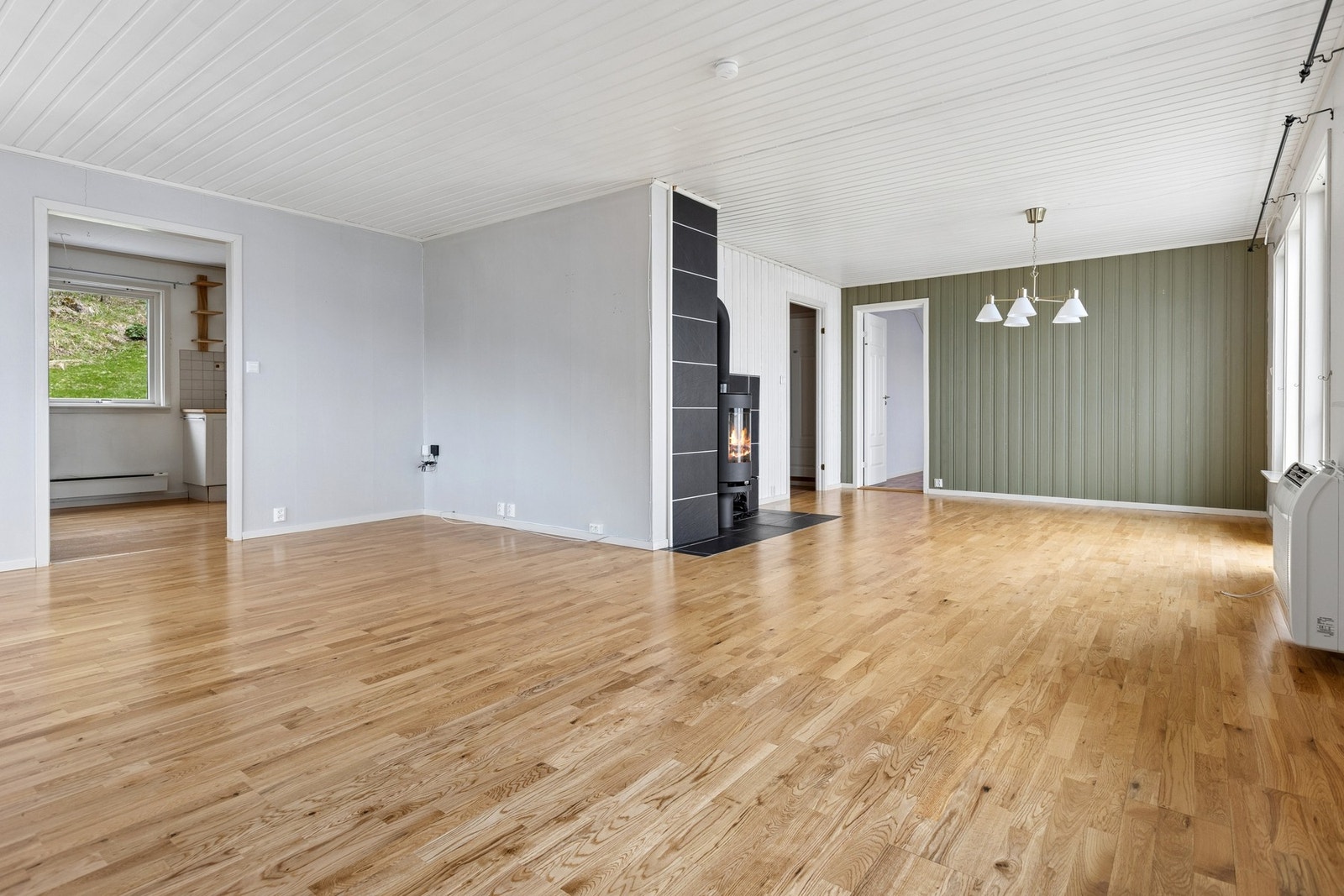 Hovedetasjen har en åpen og luftig stue med parkett på gulvet og plass til flere sittegrupper. Foto: EFKT Galleribilde