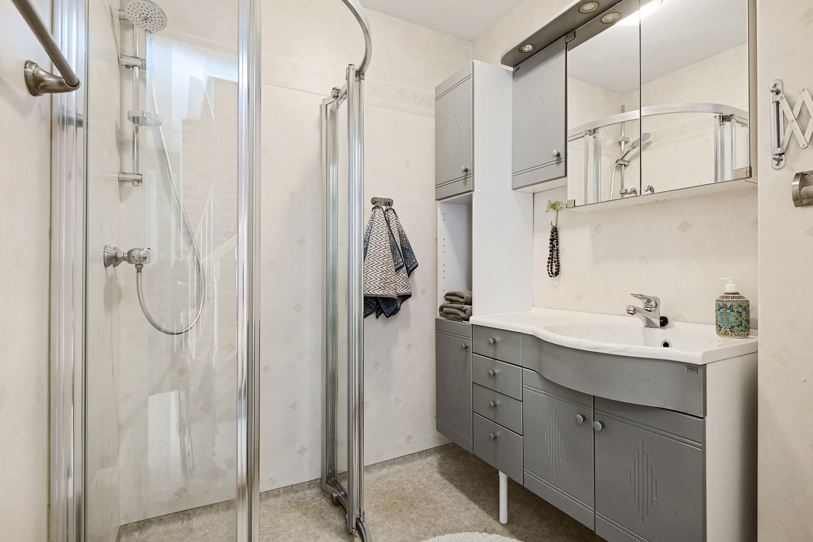 Badet i underetg. har belegg på gulv og baderomstapet på vegg- installert stor baderomsinnredning samt dusjhjørne Galleribilde