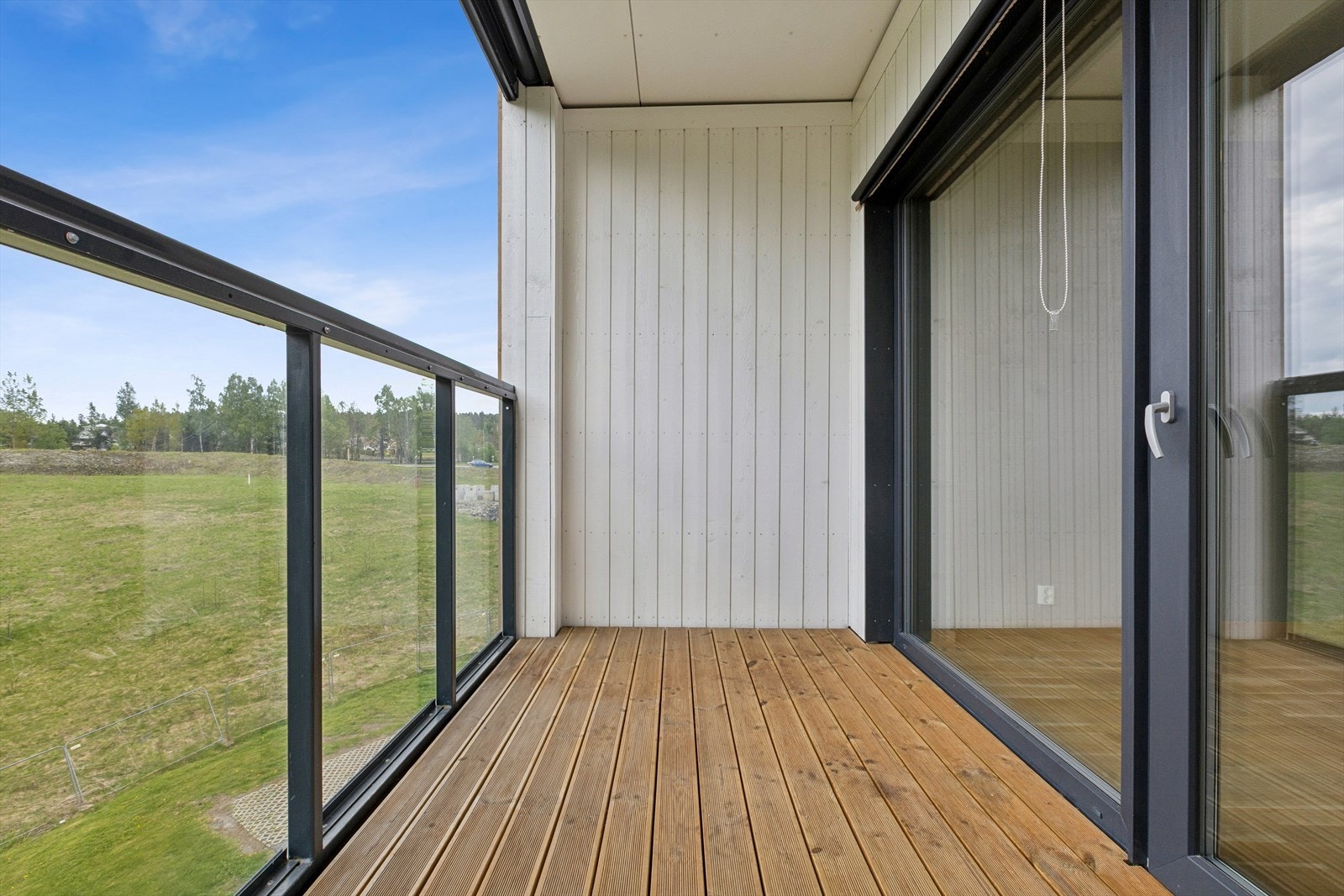 Glassrekkverket på balkongen gir en åpen og luftig følelse, samtidig som innglassingen gir ly for vær og vind. Galleribilde