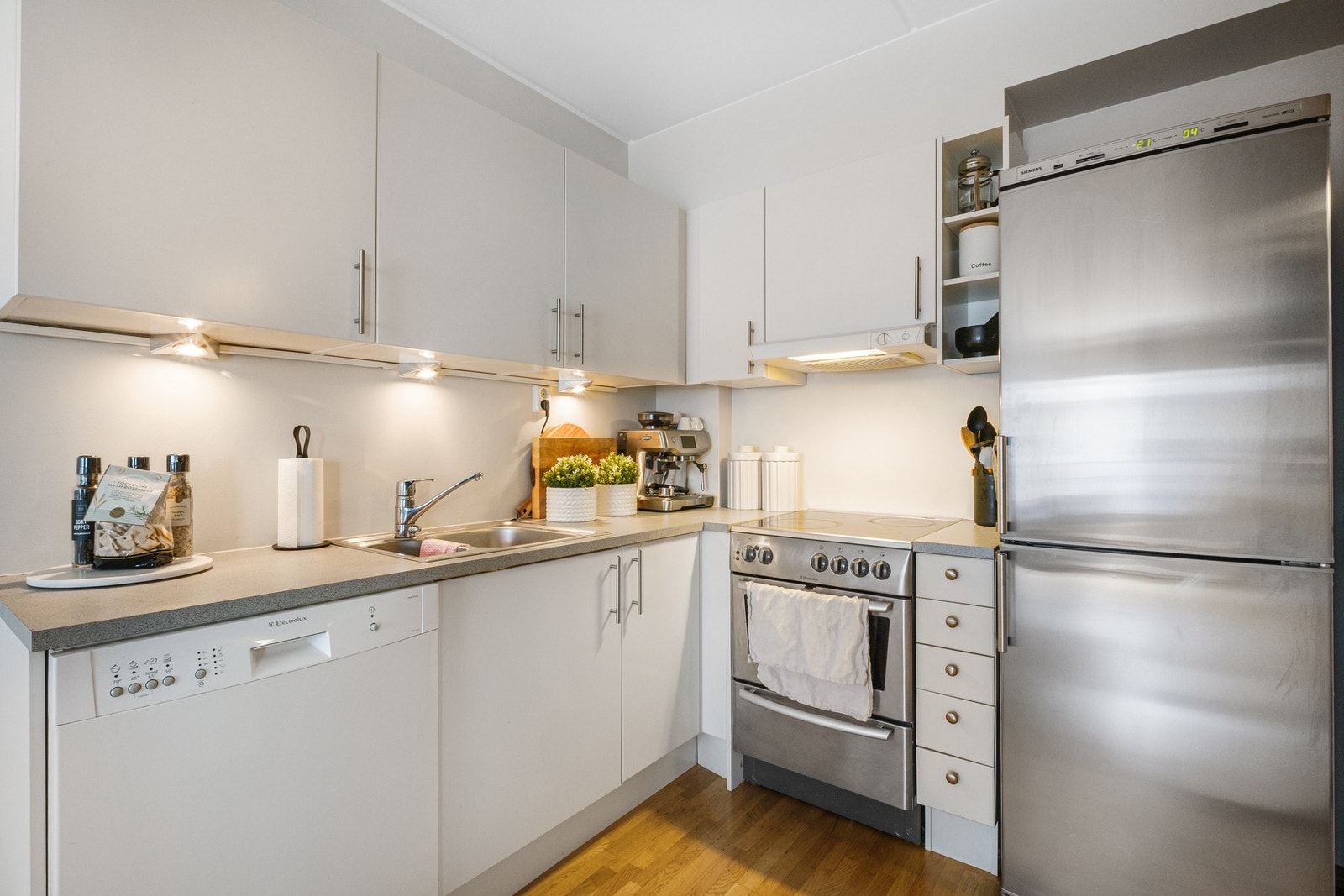Kjøkkenet har en lys og tidløs innredning fra byggeår med glatte fronter, laminert benkeplate, oppvaskkum, ventilator og opplegg for oppvaskmaskin. Galleribilde