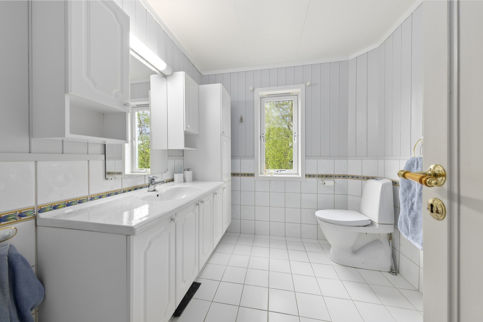 Badet i hovedetasjen har fliser på gulv og vegger, samt elektriske varmekabler i gulvet. Galleribilde