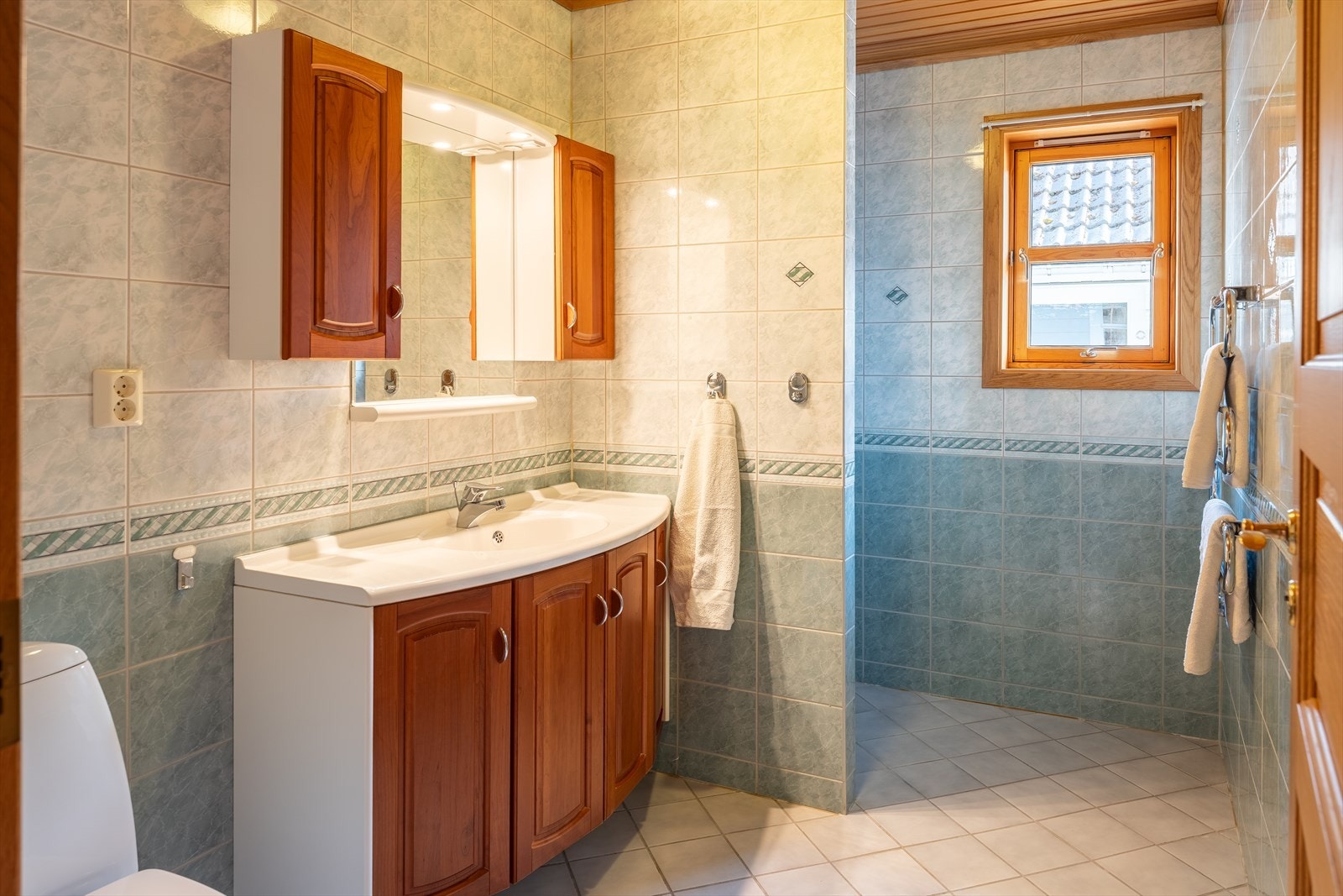 Flislagt bad med god lagringsplass og romslig dusj. Badet måler 5,5 m². Galleribilde