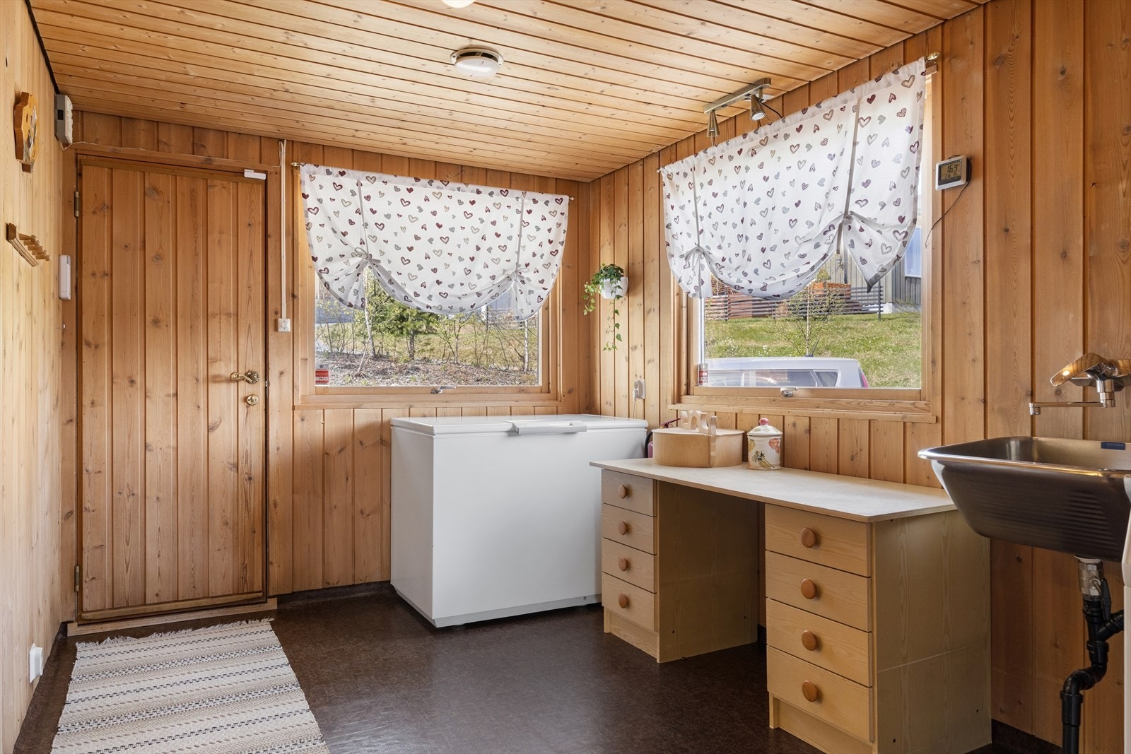 Praktisk vaskerom med utslagsvask og opplegg for vaskemaskin. Galleribilde