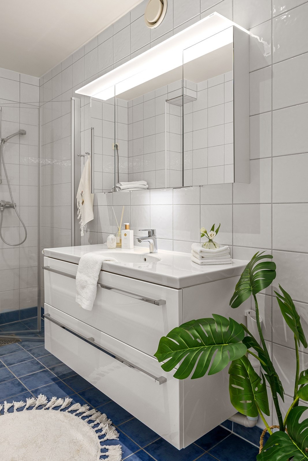 Badet er utstyrt med heldekkende servant med underskap, speil med lys, dusjnisje og toalett Galleribilde