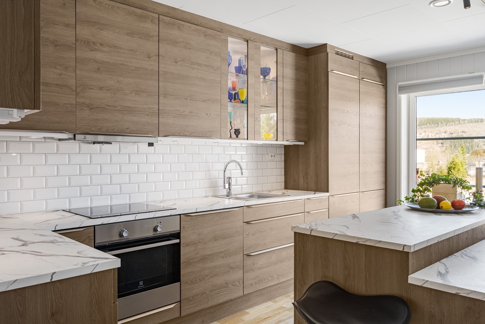 Kjøkkenet har innredning med glatte fronter og benkeplate av laminat. Kjøkkenventilator med avtrekk ut. Galleribilde