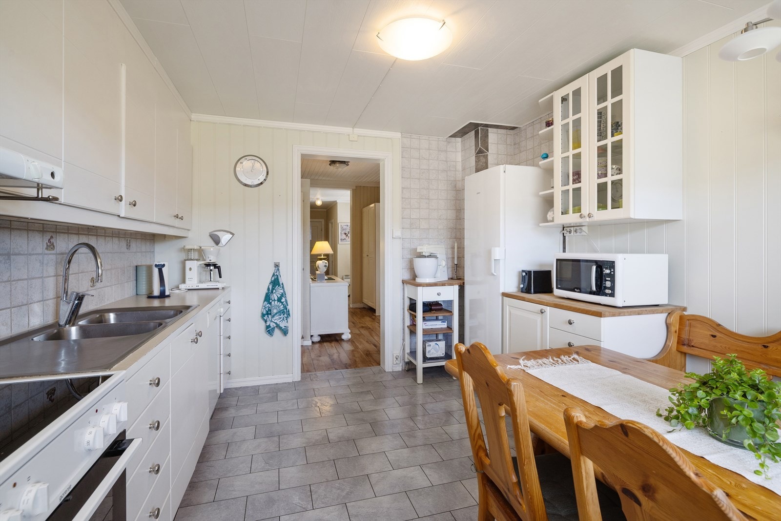 Kjøkkeninnredningen har glatte fronter og benkeplate i laminat. Kjøkkenventilator med avtrekk ut. Galleribilde