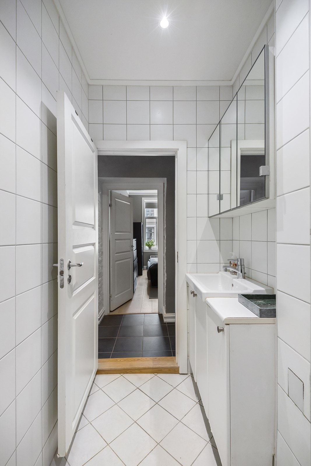 Badet er lyst og flislagt med 20 x 20 cm fliser på gulv og vegger. Himlingen har malt overflate og downlights, og elektrisk gulvvarme gir god komfort i hverdagen. Galleribilde