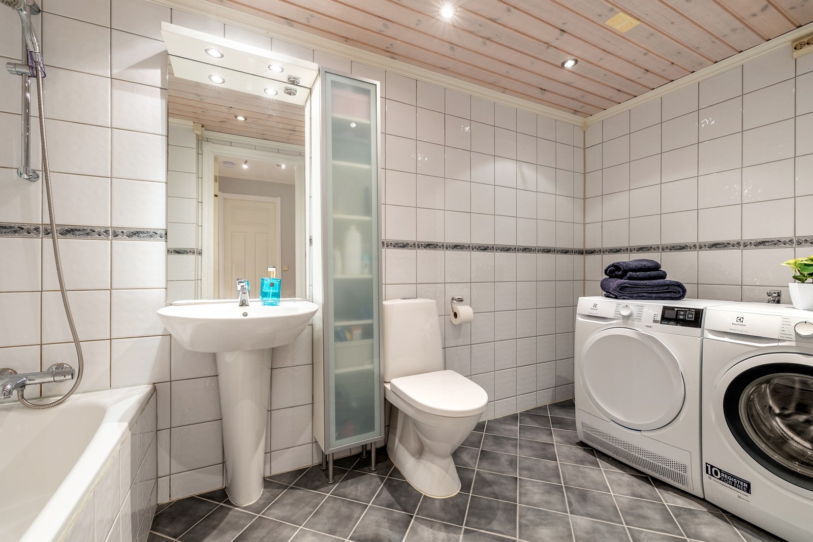 Badet ligger i boligens underetasje og er utstyrt med flislagte vegger og gulv, varmekabler og downlights. Badet er innredet med servant, toalett og badekar. Galleribilde