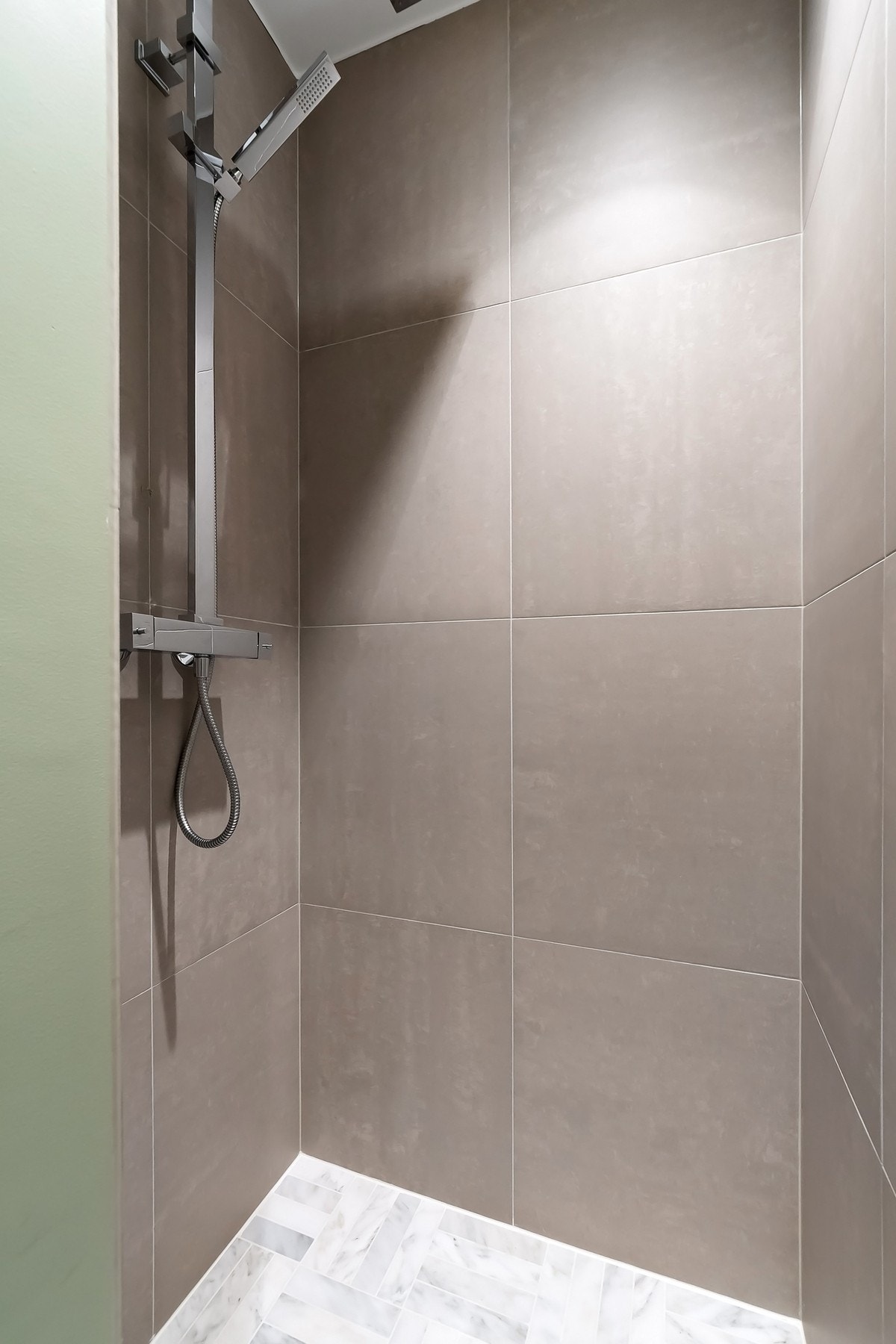 Dusjsonen har regnfallsdusj og hånddusj og ligger i egen ende av badet. Galleribilde