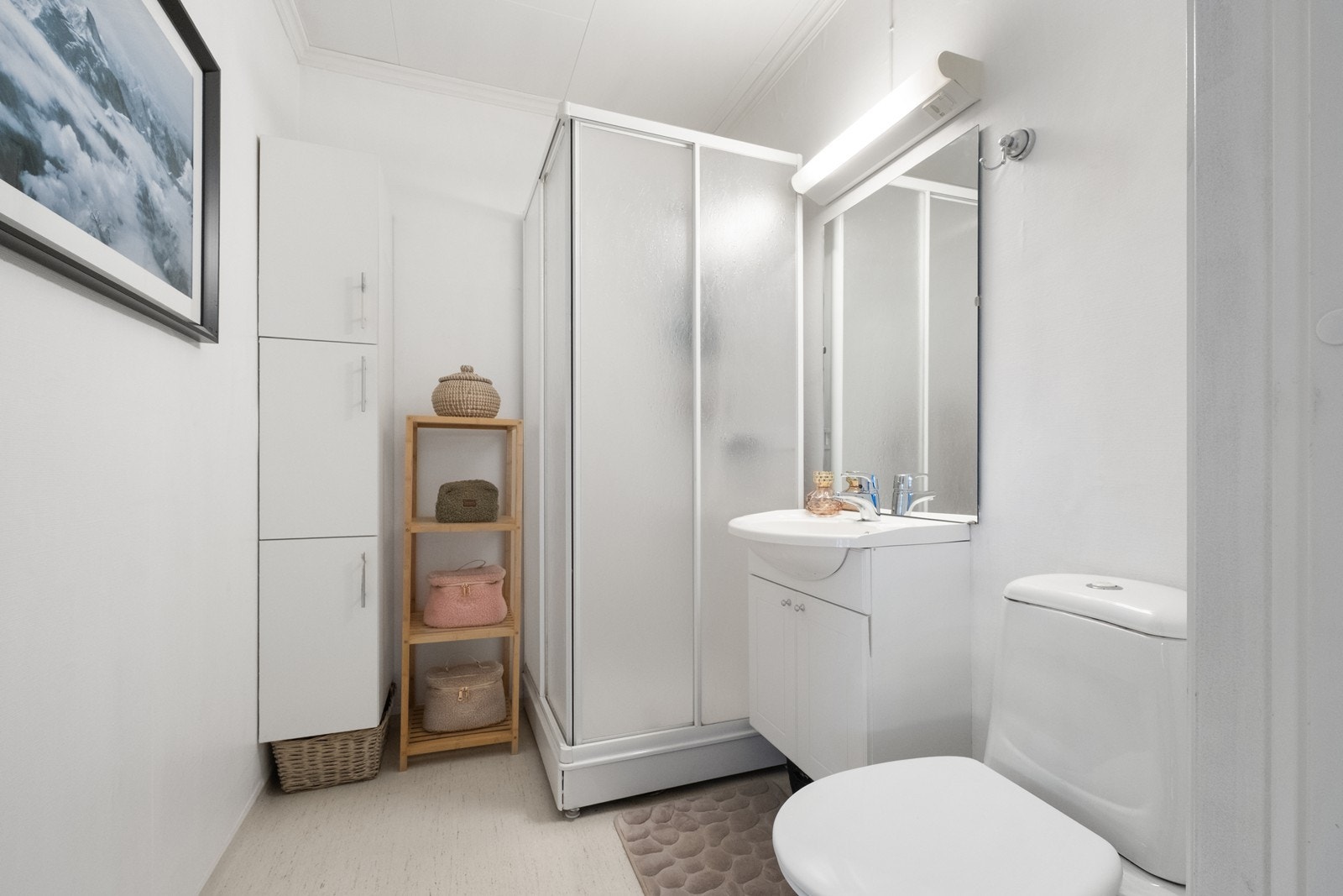 Badet er utstyrt med wc, servant med underskap, dusjkabinett og høyskap. Galleribilde