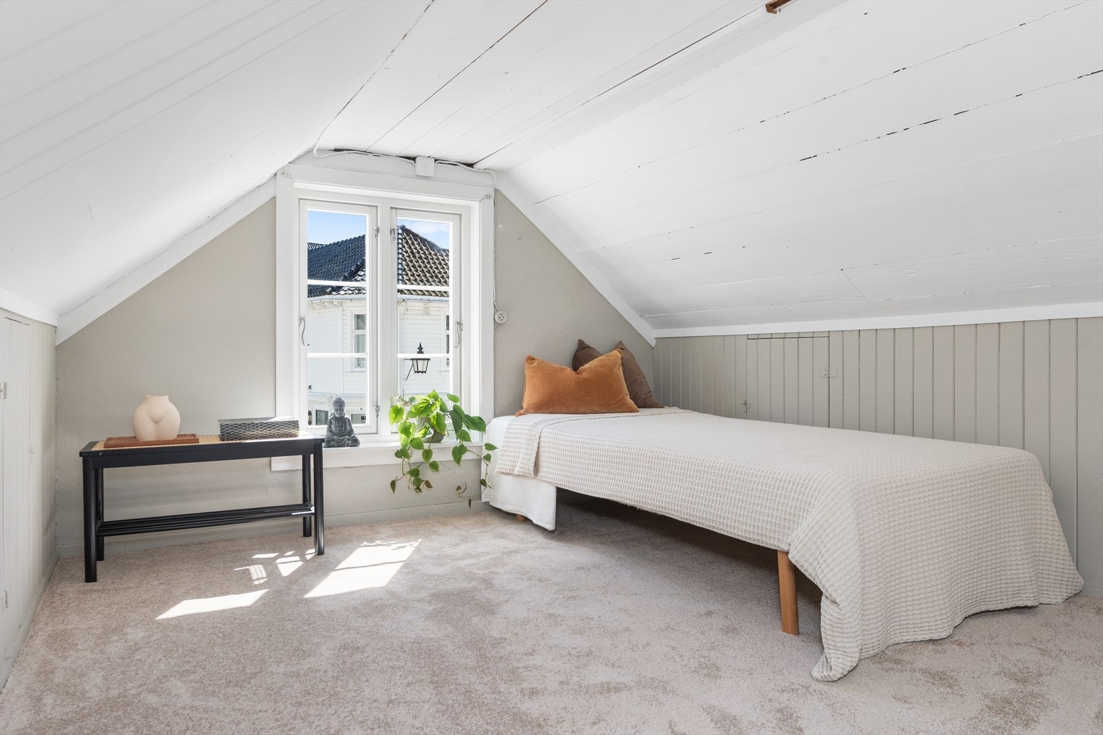Rommet har teppe på gulvet og panel på deler av veggen. Galleribilde