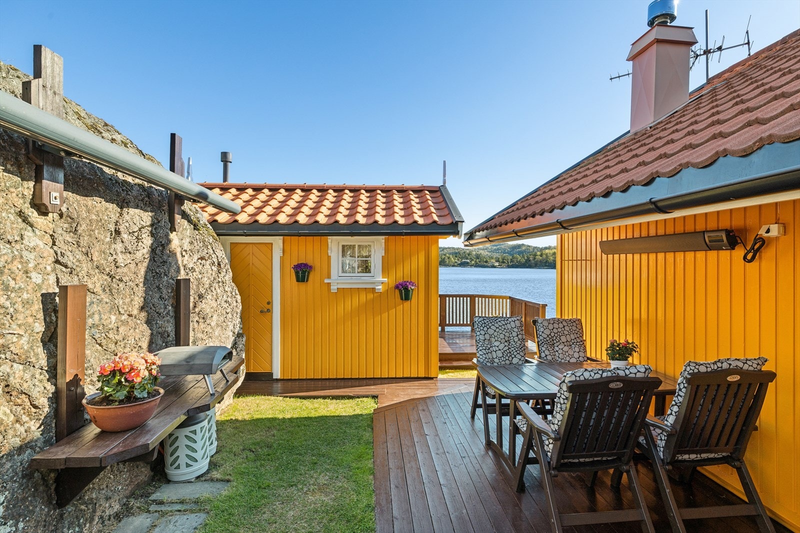 Mellom hytta og uthuset er det en lun og skjermet uteplass. Med ny varmovn (2025) og markise montert på fjellet for ekstra varme på sommerkveldene. Galleribilde