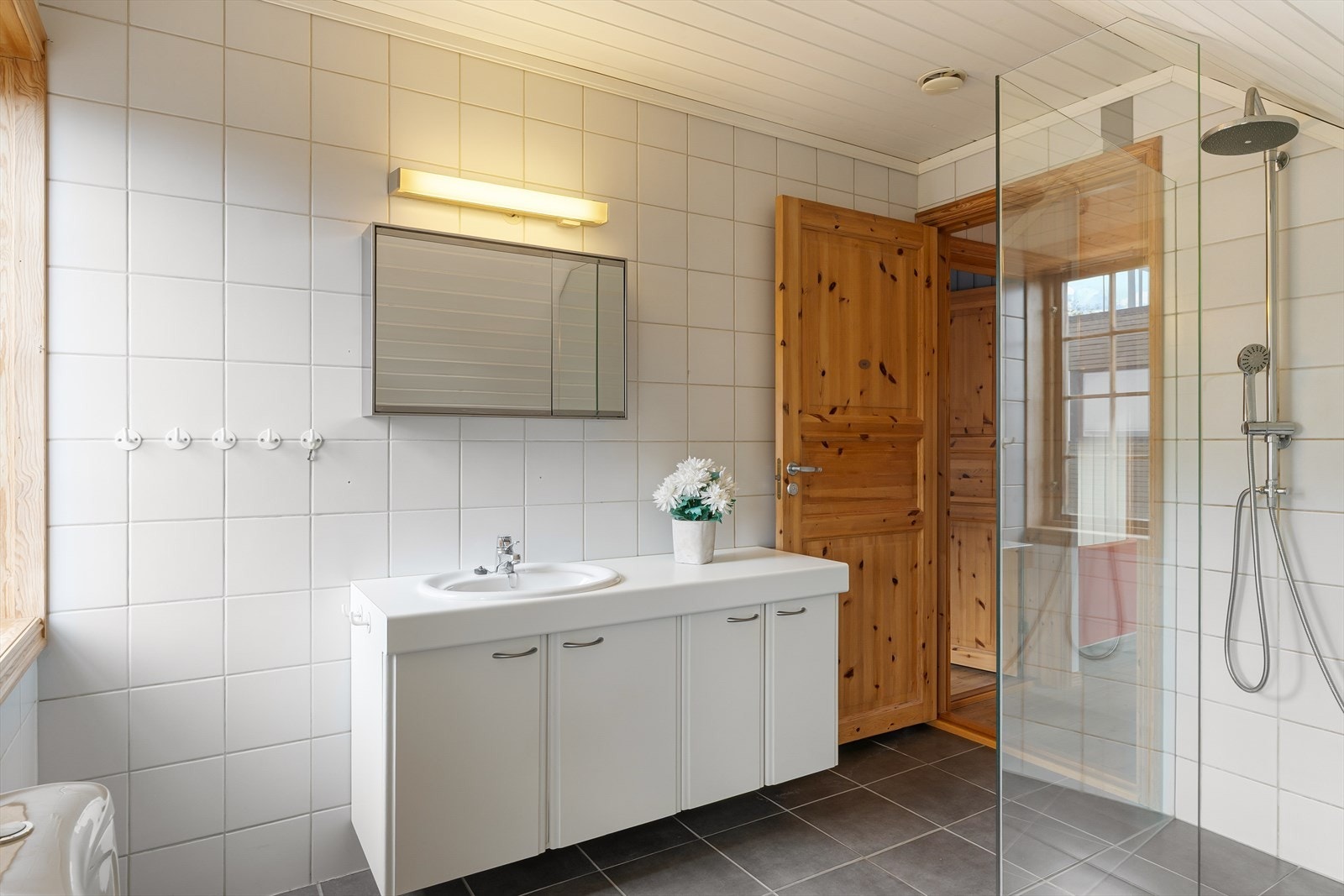 Badet i andre etasje har flislagte overflater, dusjvegger i glass og veggskap med speilfronter. Galleribilde