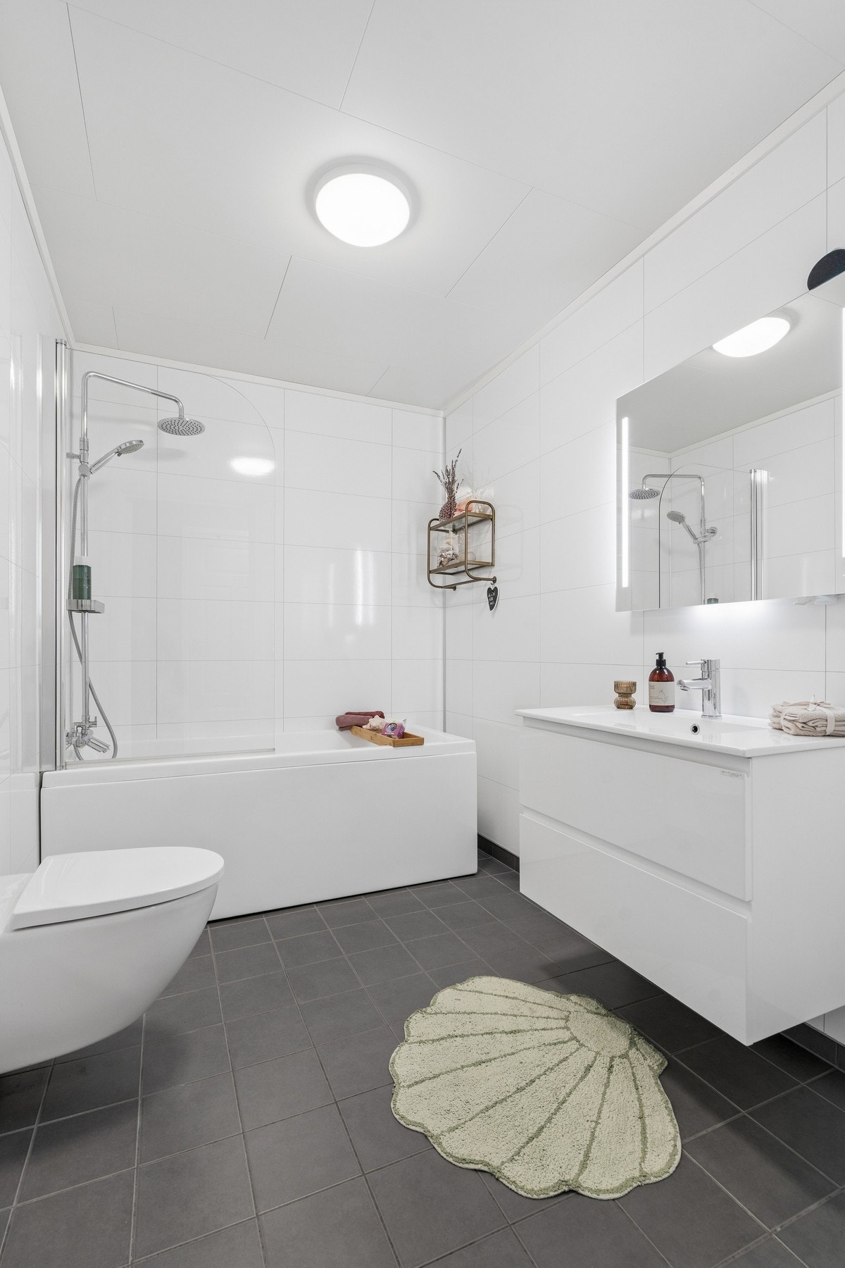 Badet i første etasje har flislagt gulv med elektriske varmekabler, veggmontert toalett og badekar. Galleribilde