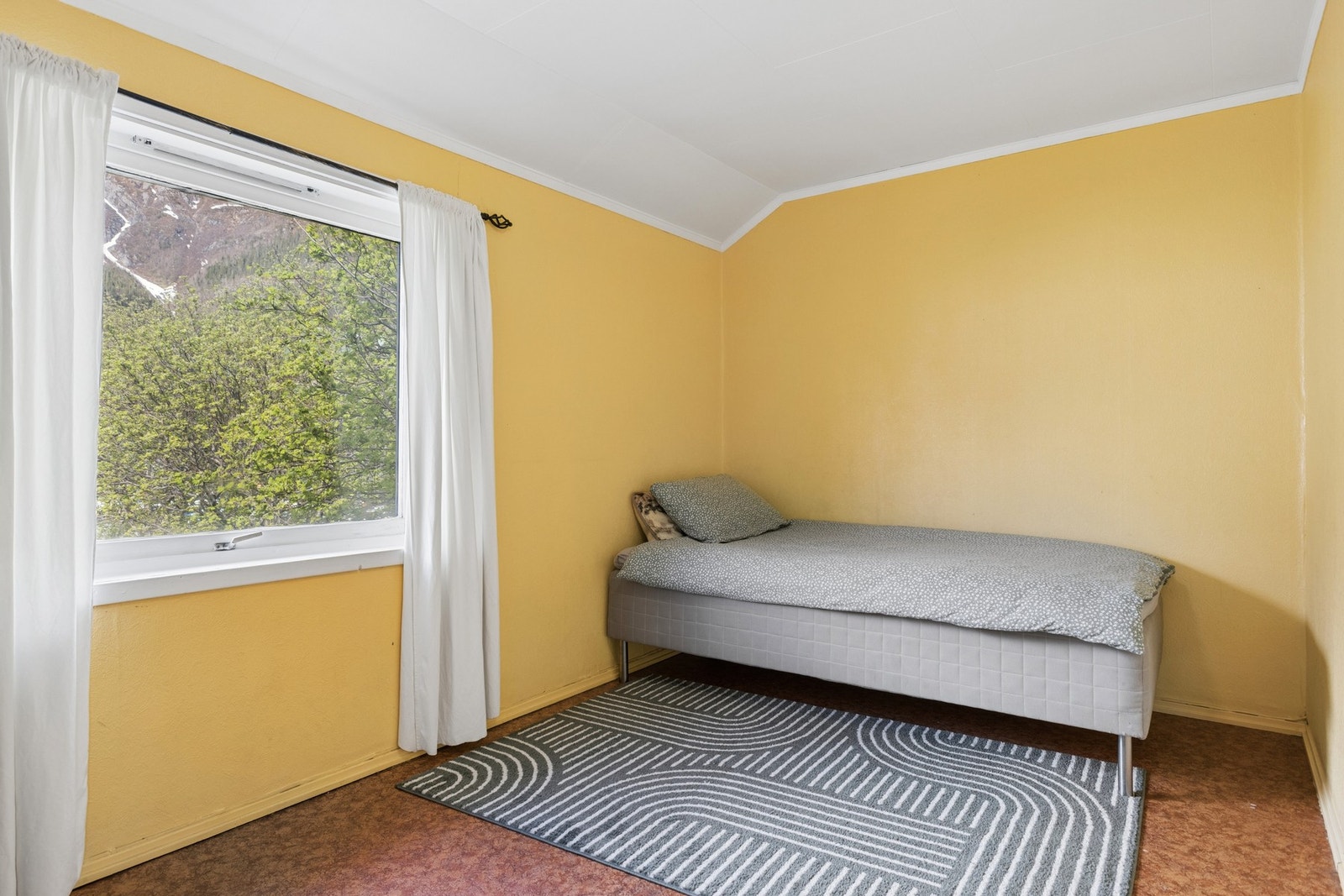 Boligens andre soverom, lyst og med plass til seng og oppbevaring. Galleribilde