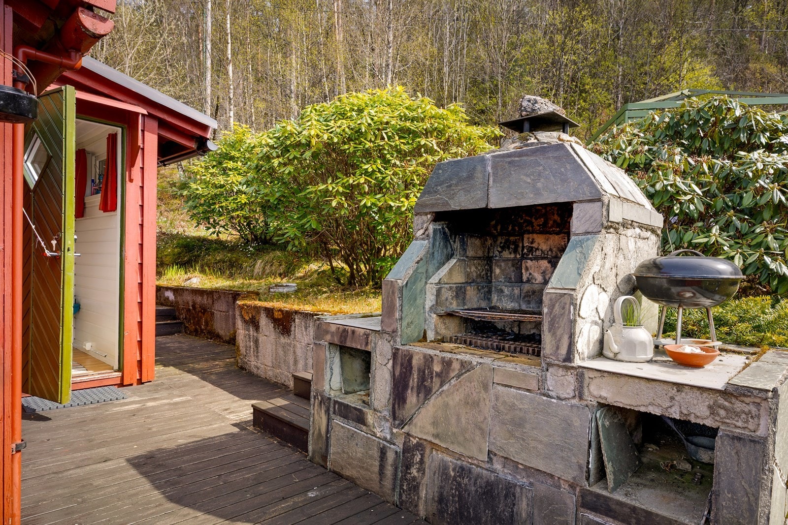 En solid, murt utegrill er et naturlig samlingspunkt for måltider i det fri. Galleribilde