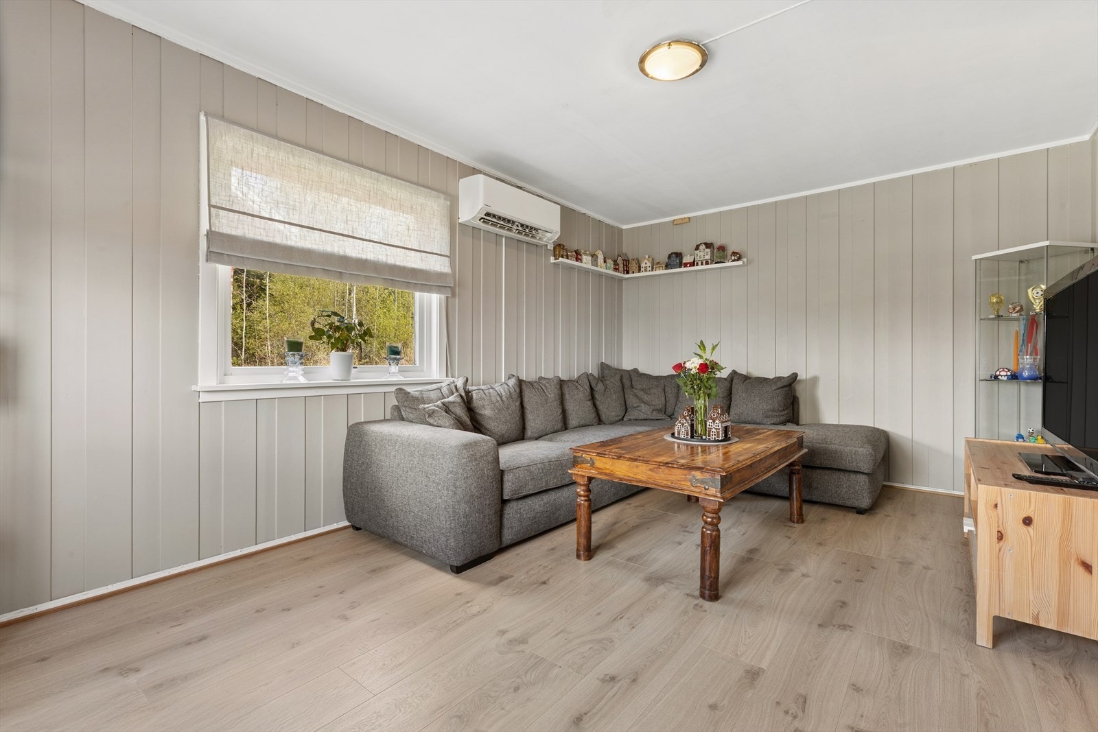 En av stuene, med plass til en romslig sofagruppe. Oppvarming i boligen suppleres av en varmepumpe. Galleribilde