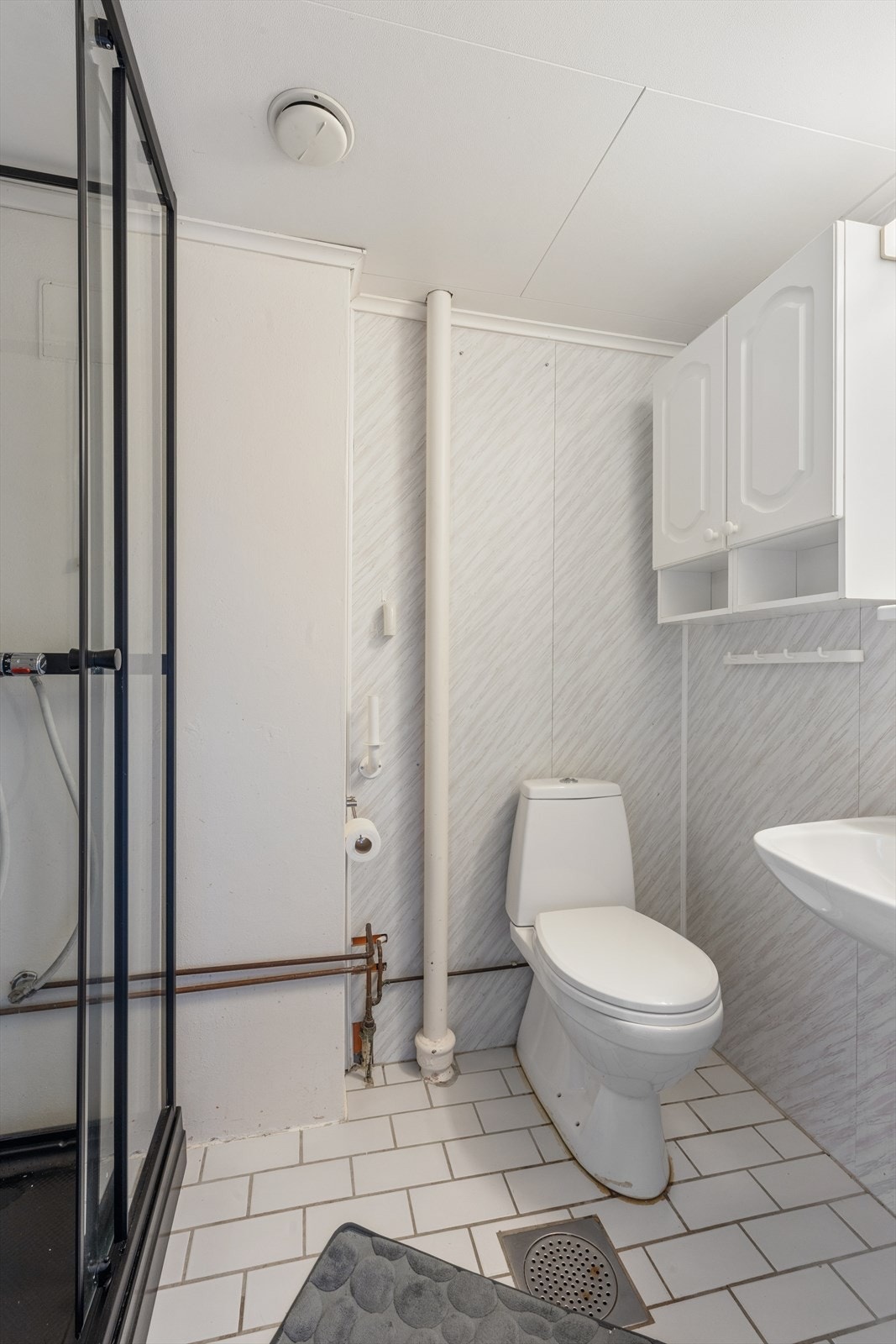 Badet på loftet er utstyrt med dusjkabinett, toalett og servant. Rommet har fliser på gulv og våtromsplater på veggene. Galleribilde