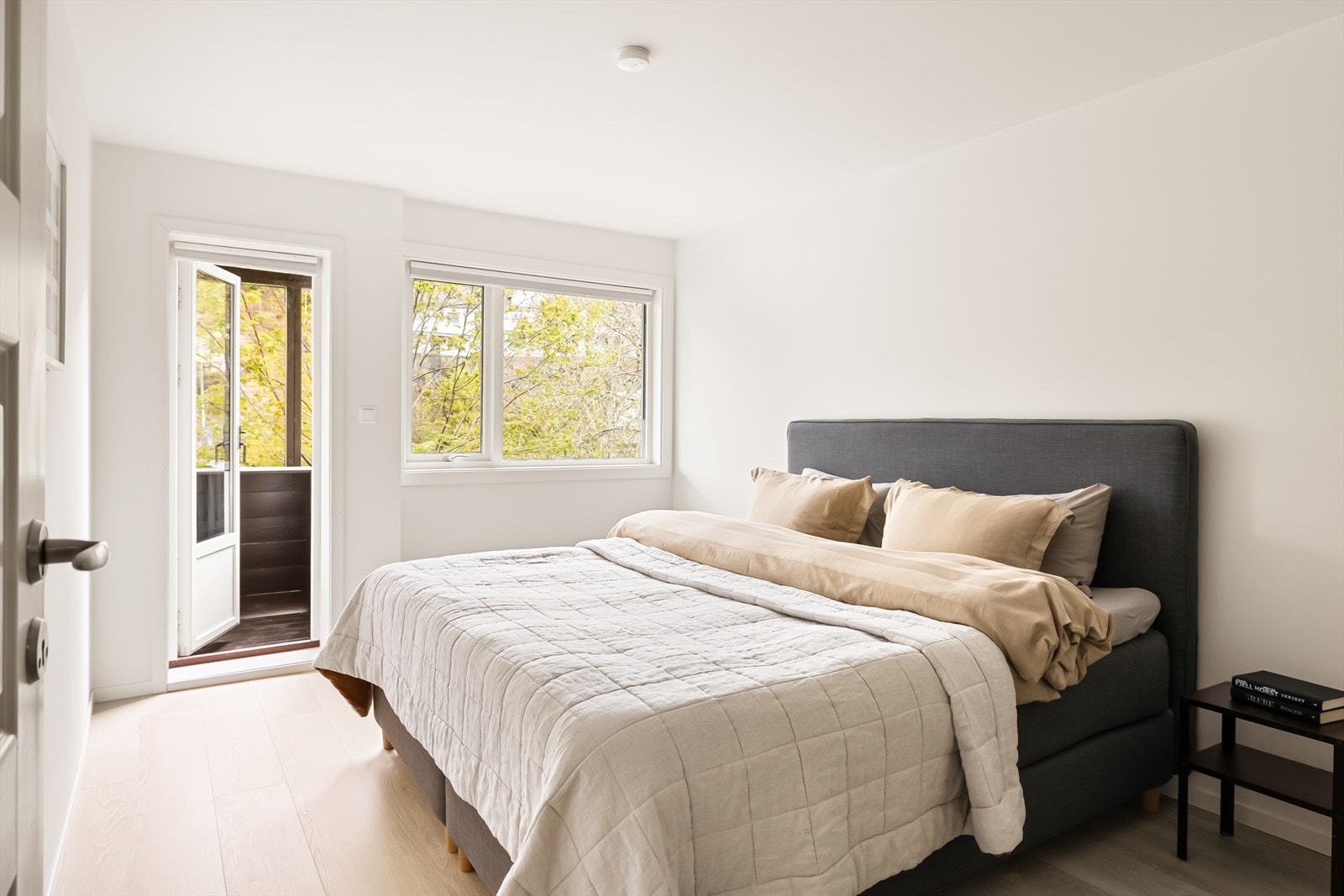 Lyst og moderne hovedsoverom med utgang til balkong og uteområde. Galleribilde