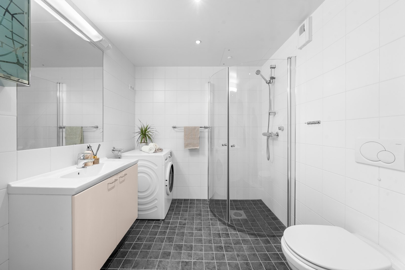 Romslig og pent flislagt bad med behagelig gulvvarme og downlights i himling. Galleribilde