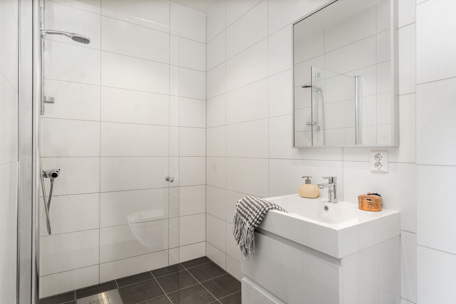 Rommet har direkte adkomst til bad på 4m². Badet er utstyrt med vegghengt toalett, dusjørne og hvit baderomsinnredning (Vikingbad). Galleribilde