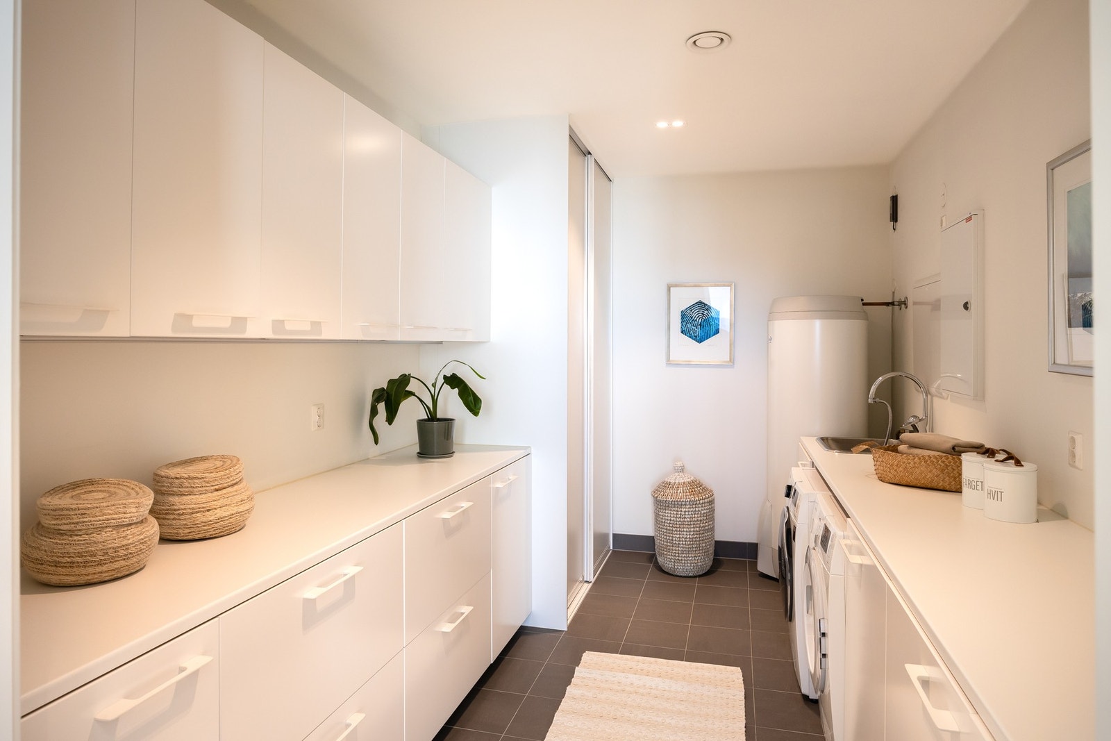 Eget vaskerom på 11m². Vaskerommet er rikelig utstyrt med skap, utslagsvask og benkeplater. Skyvedørsgarderobe som skjuler anlegget for den balanserte ventilasjonen. Galleribilde