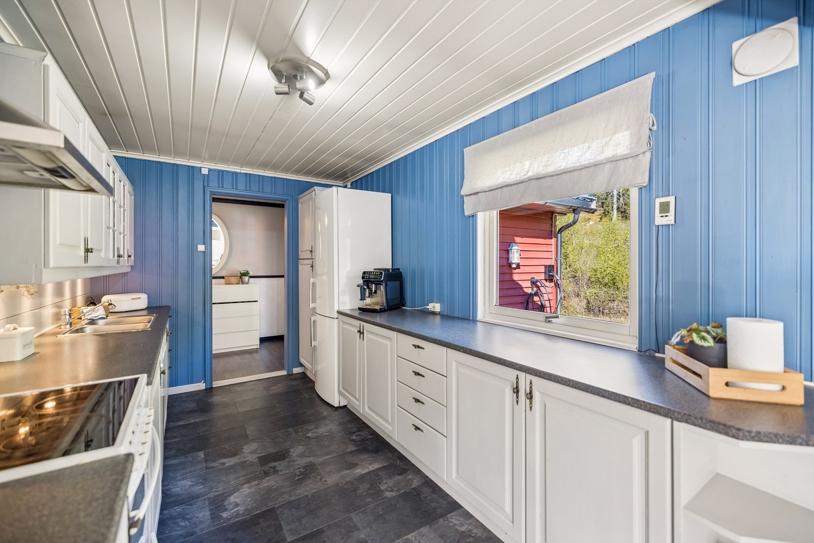Kjøkkeninnredning med malte heltre speilfronter og en slitesterk laminatbenkeplate. Galleribilde
