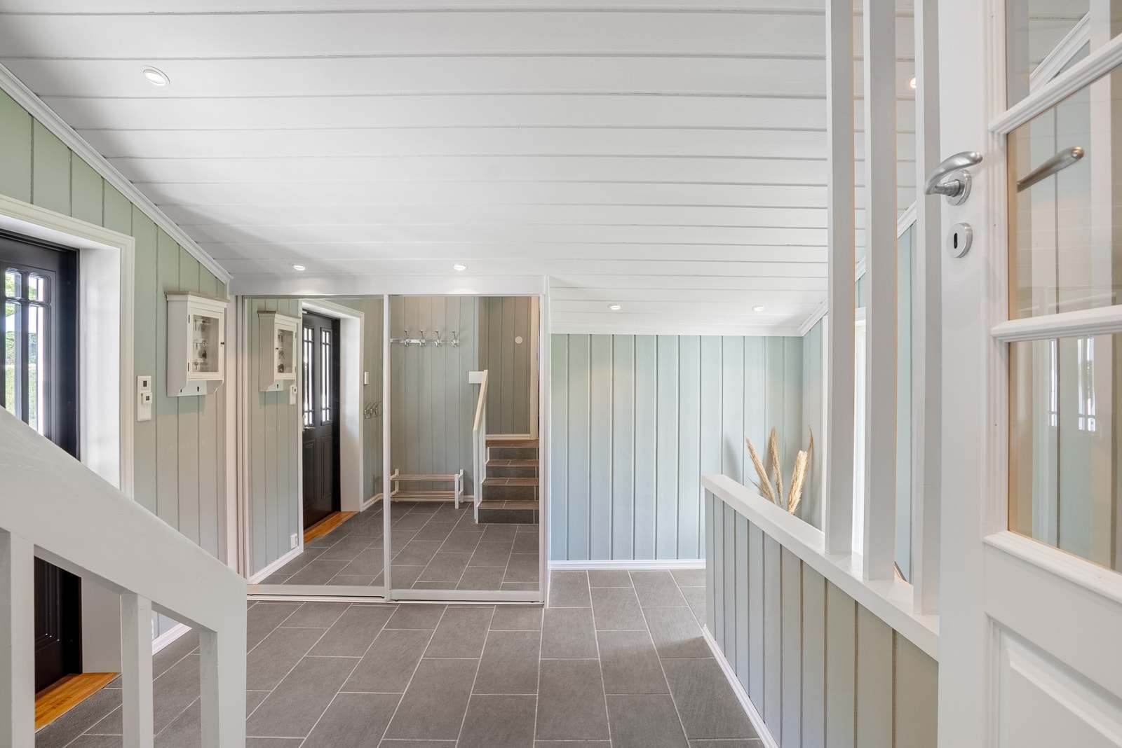 Romslig entré innredet med skyvedørsgarderobe for oppbevaring av yttertøy Galleribilde