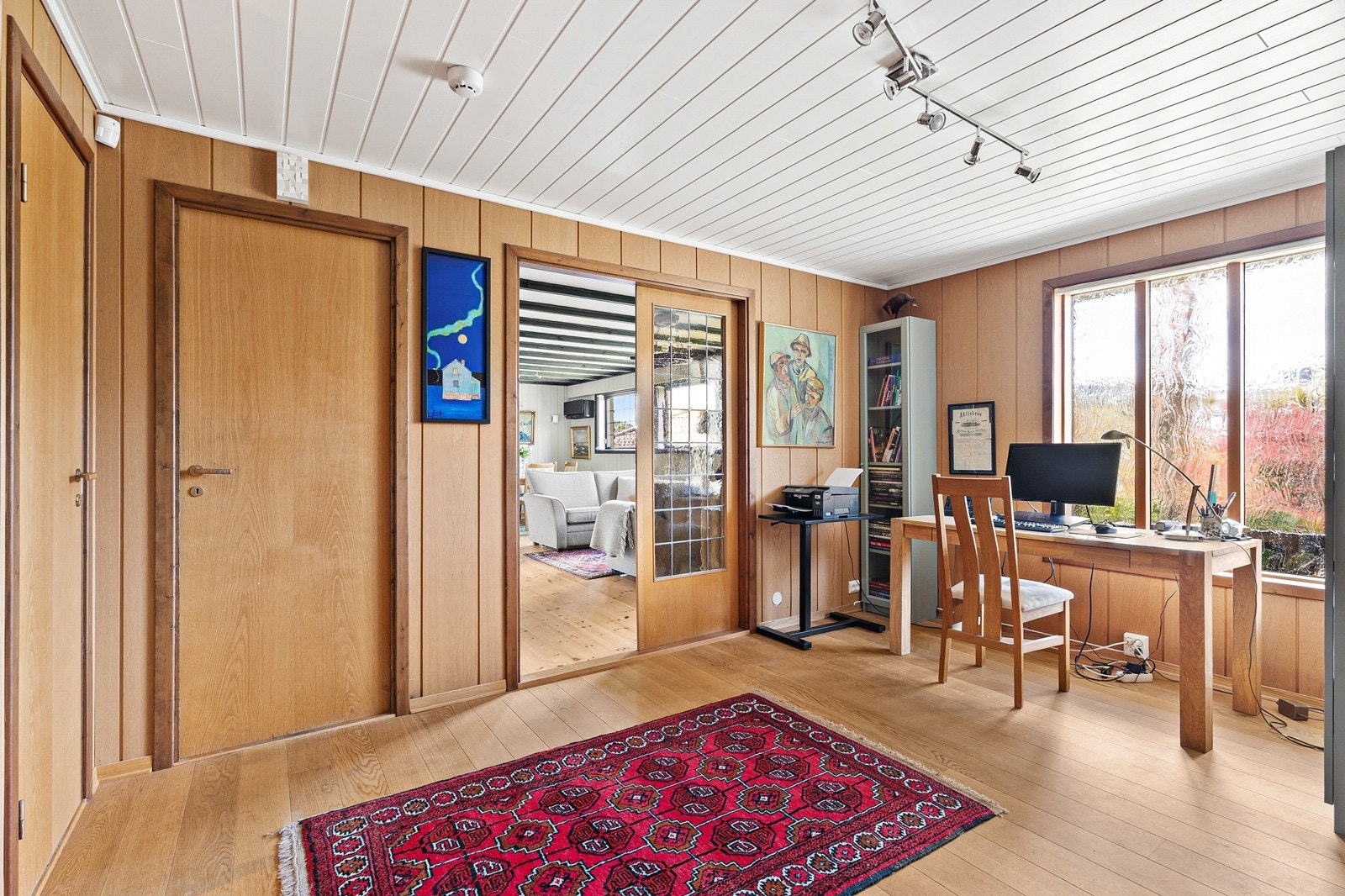 Hall med vegger som er kledd med eikefiner pg parkett på gulv. Galleribilde