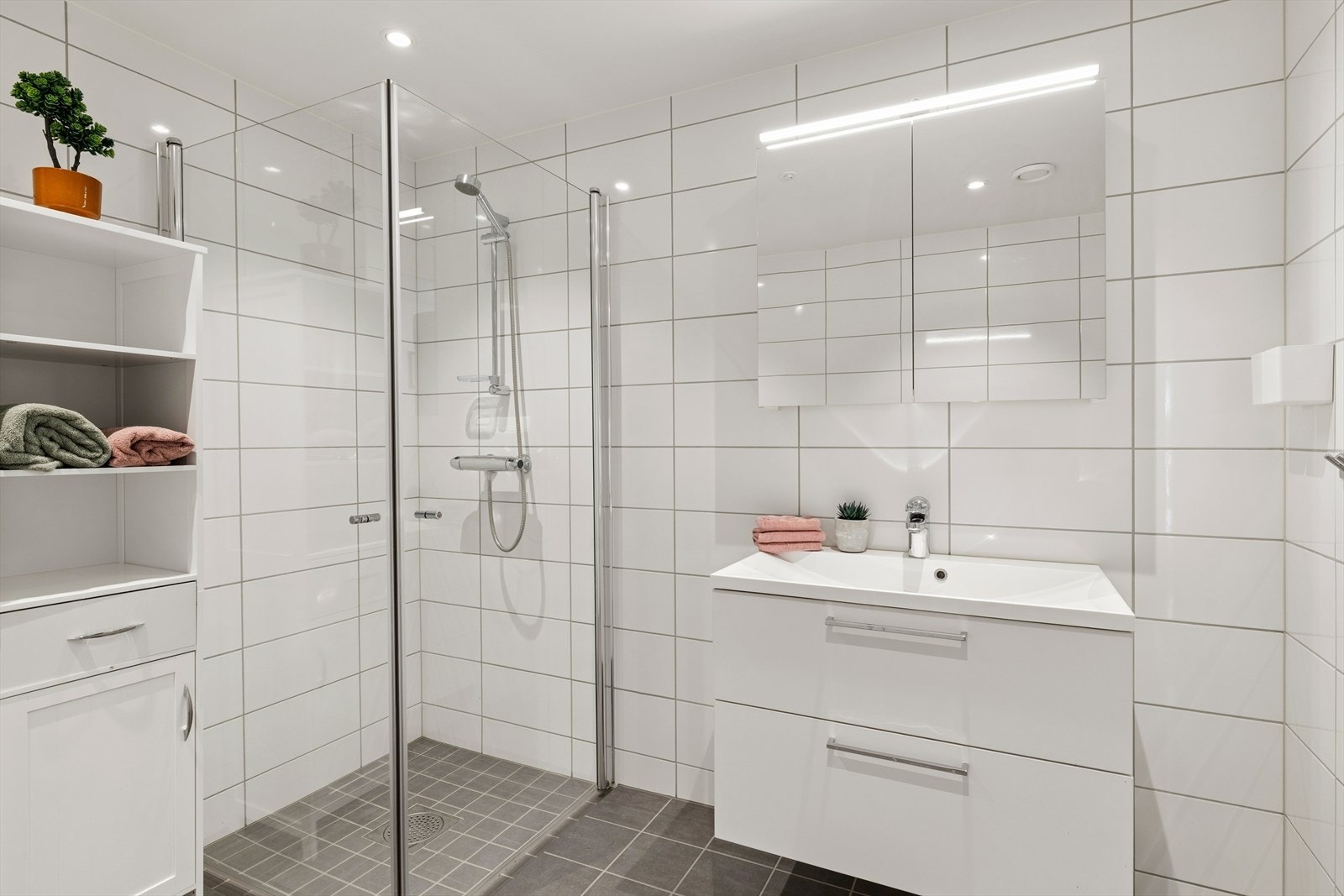 På badet er det dusjnisje med dusjdører, vegghengt toalett, baderomsinnredning og speilskap. Galleribilde