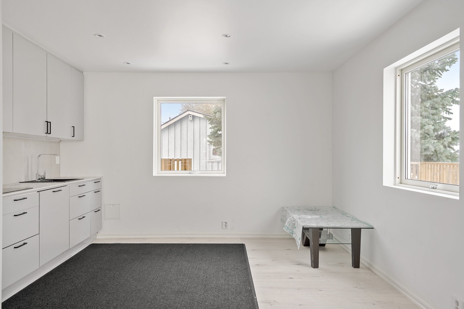 Vinduer på to kanter slipper inn fint med naturlig lys til rommet. Her er det plass til kjøkkenbord. Galleribilde
