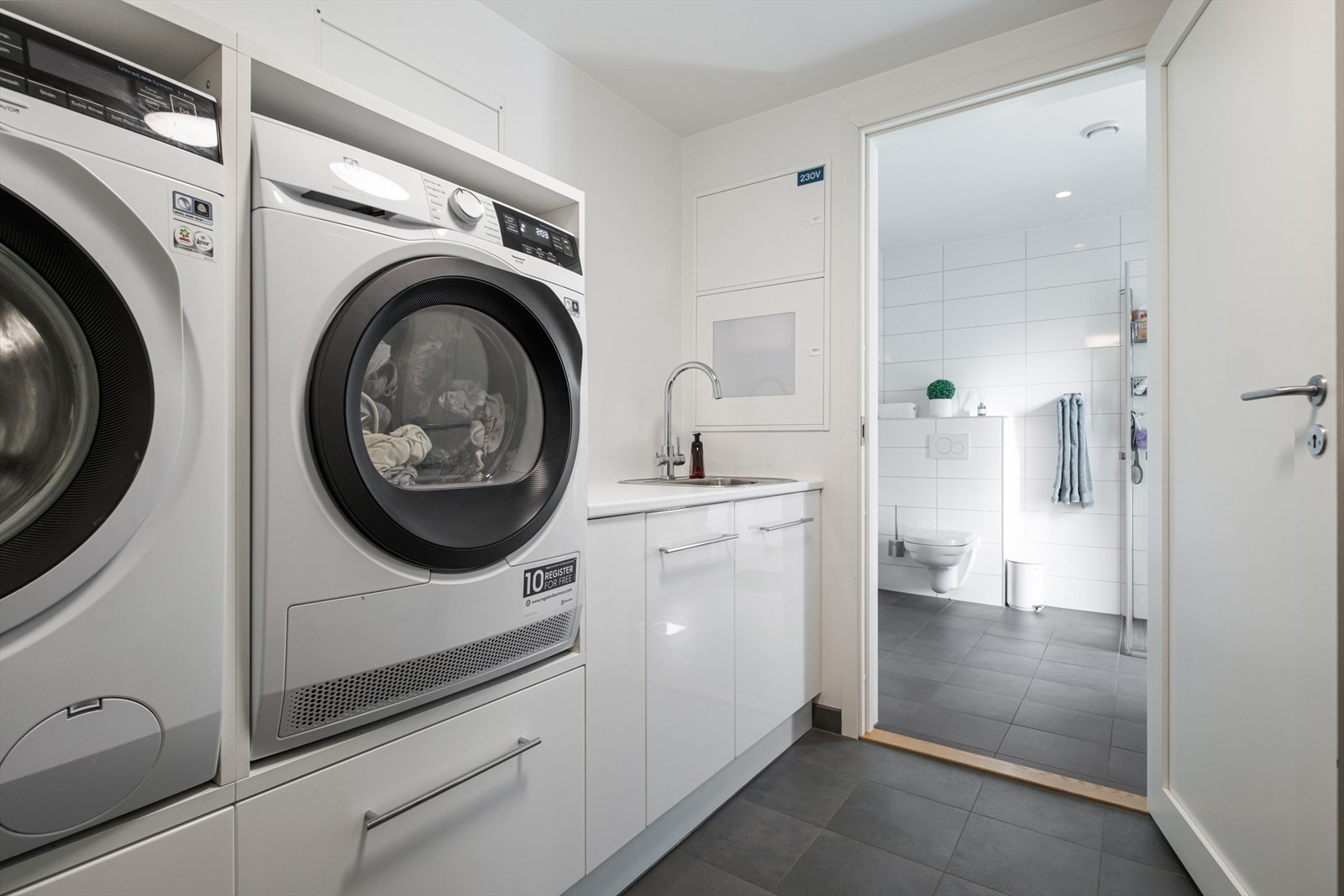 Direkte tilgang fra badet til vaskerom gir praktisk brukervennlighet og effektiv utnyttelse av våtrommene. Galleribilde
