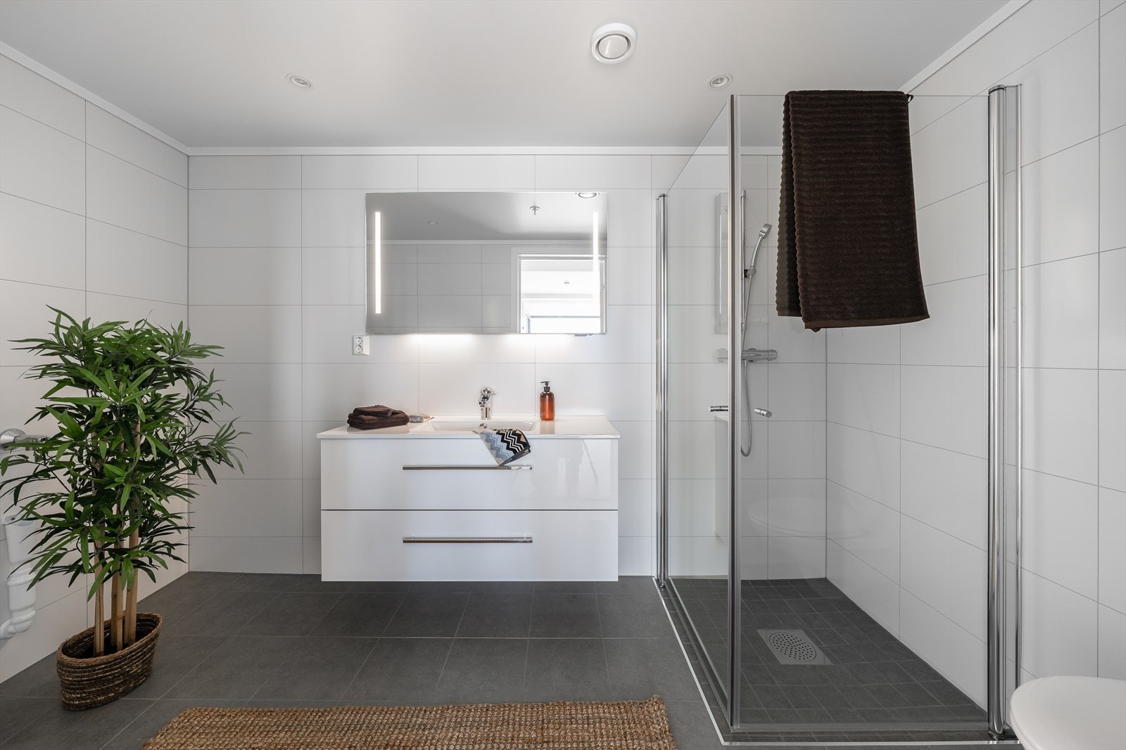 Badet tilliggende hovedsoverom er helfliset og utstyrt med en bred servantinnredning med doble skuffer. Galleribilde