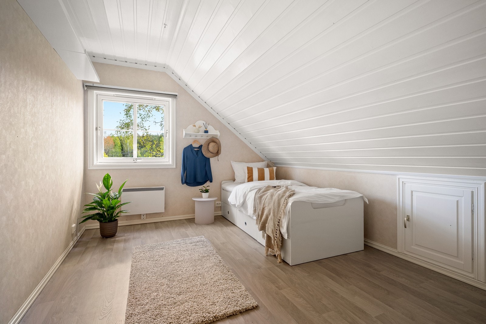Soverom med laminatgulv og smart utnyttelse av plassen under skråtaket. Galleribilde