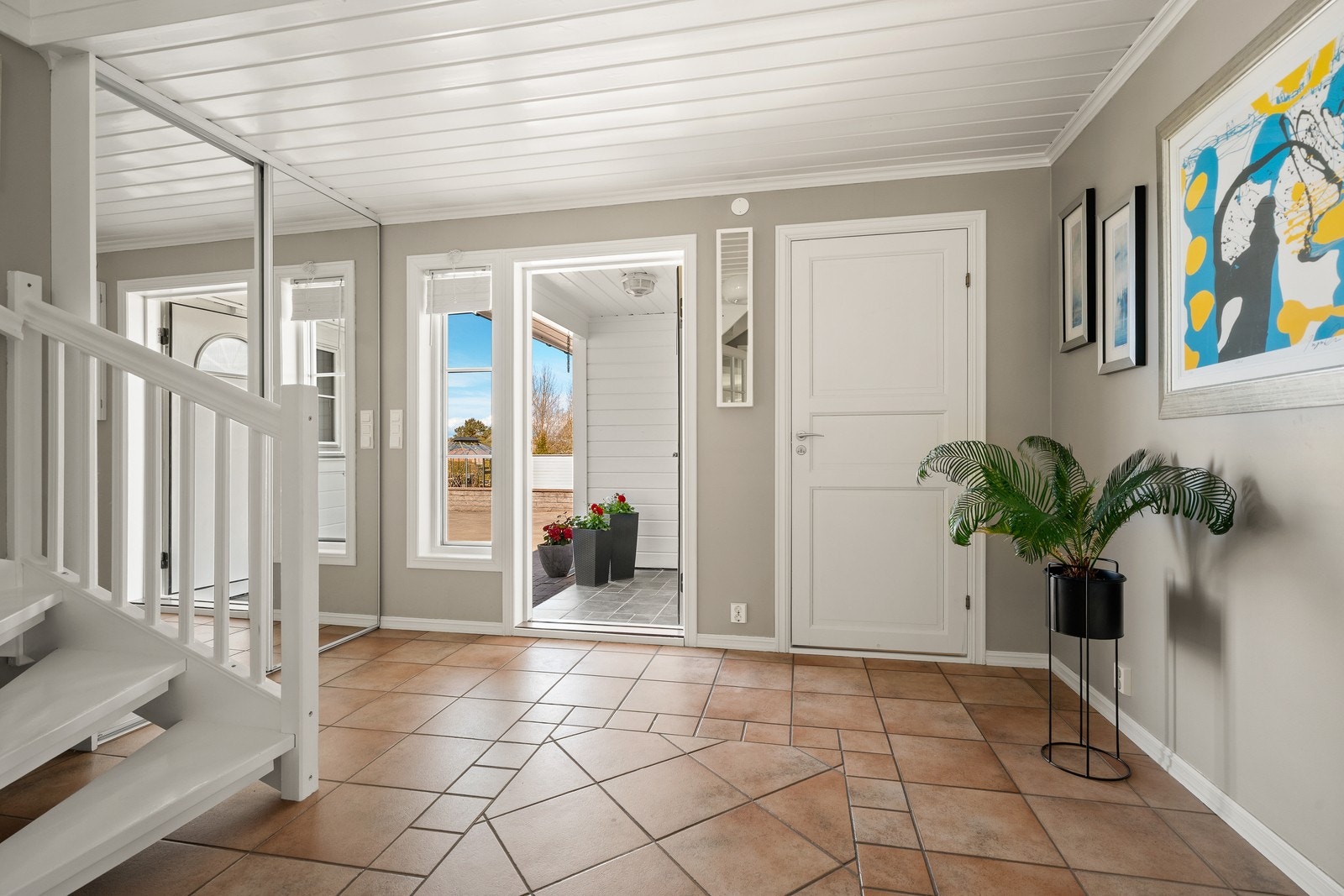 Hallen har flislagt gulv med elektrisk gulvvarme og en romslig skyvedørsgarderobe. Galleribilde
