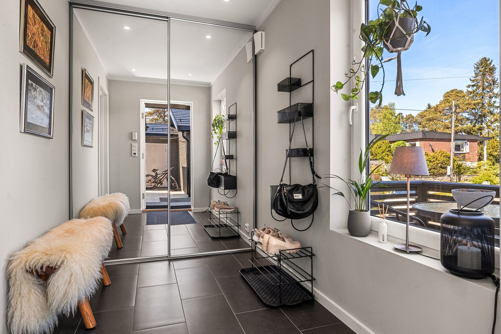 Romslig entré med flislagt gulv med varmekabler og skyvedørsgarderobe med speilfronter. Galleribilde