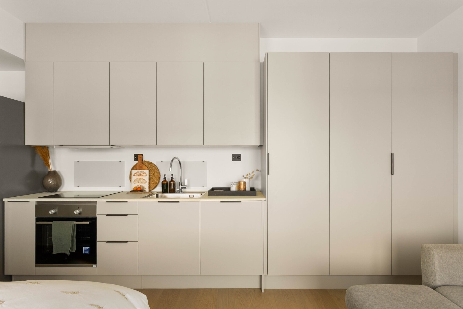 HTH-kjøkken med moderne og stilrent uttrykk, glatte fronter og integrerte hvitevarer som induksjonstopp, stekeovn, oppvaskmaskin og ventilator. Galleribilde