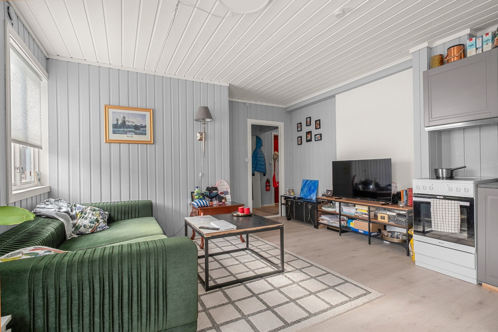 Her får du en hyggelig oppholdssone med åpen løsning mot kjøkkenet og plass til både sofa og TV-møblement. Galleribilde