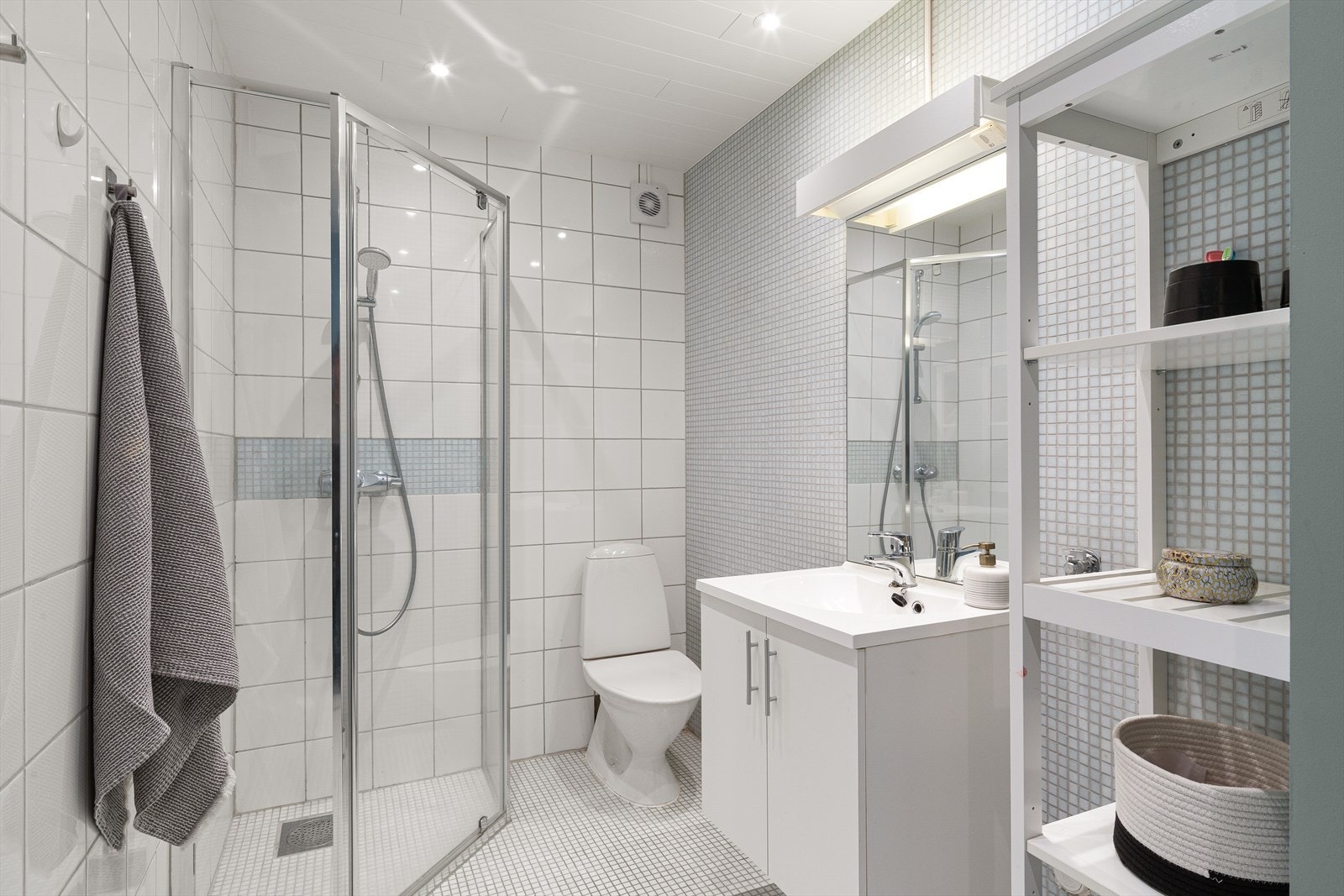 Badet er fra ca. 2010 med flislagt gulv, dusjhjørne med glassvegger og servantinnredning. Galleribilde