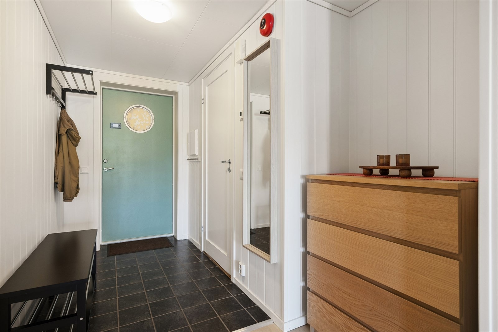 Et praktisk innhuk i entréen gir rom for oppbevaringsmøbler. Galleribilde