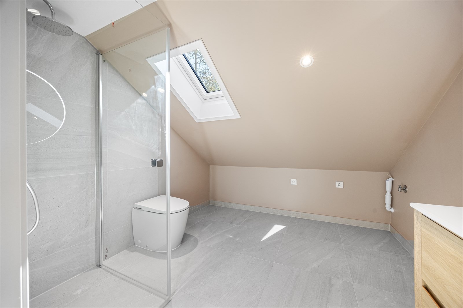 Badet i 2. etasje er med flislagt gulv, samt flislagt i dusjsone. Baderomsinnredning, speil, samt wc. Takvindu gir et naturlig og fin lys inn på badet. Opplegg til vaskemaskin og plass til tørketrommel ved siden av. Galleribilde