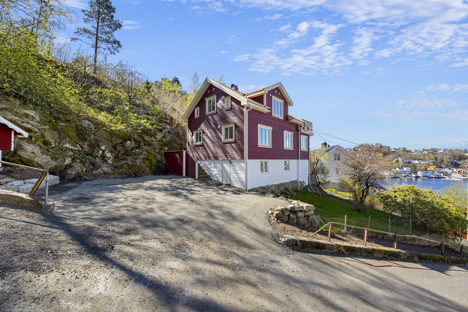 Tomten er romslig med parkeringsmuligheter og en naturlig skråning bak huset. Galleribilde