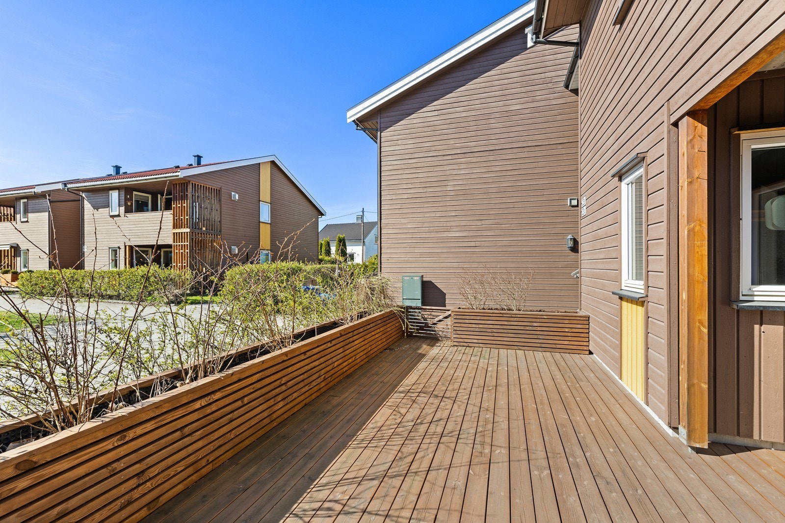 Terrassen er rammet inn av hekk og plantekasser som skjermer for innsyn. Galleribilde