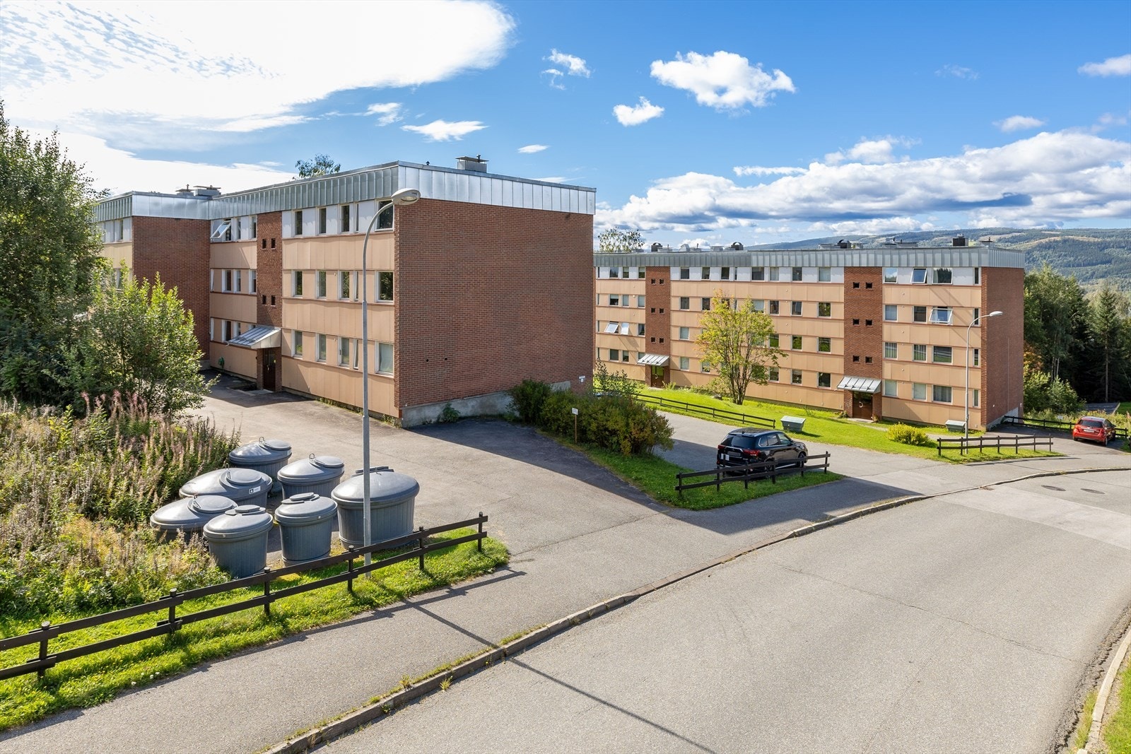 Boligblokken ligger i et skrånende terreng og eiendommen er opparbeidet med asfalterte internveier og parkeringsplasser med grøntarealer rundt om. Galleribilde