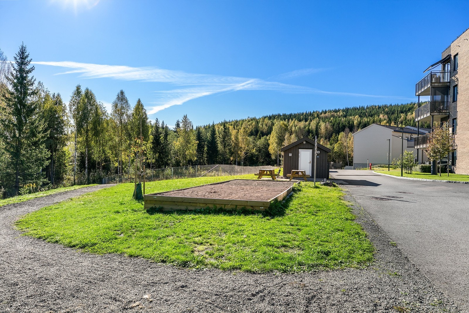 Asfalterte internveier og pent opparbeidede utearealer med beplantning. Her ser du bocciabanen. Galleribilde