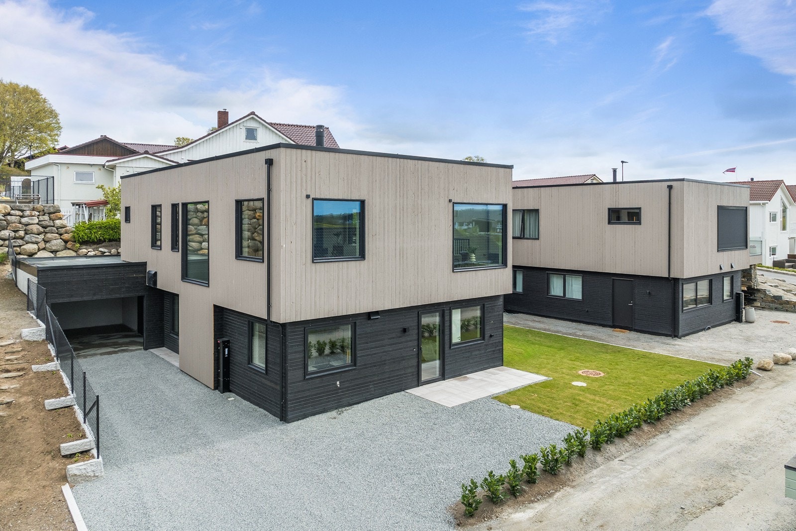 Moderne arkitektonisk uttrykk med flatt tak og kledning med to fargekombinasjoner. Galleribilde